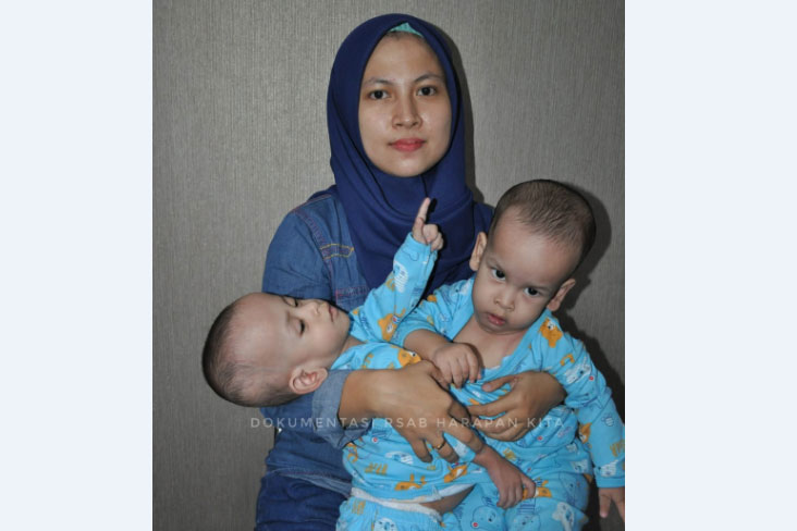 Orangtua Ardan dan Ardi, Hesti Novianti, sedang memangku kedua putranya