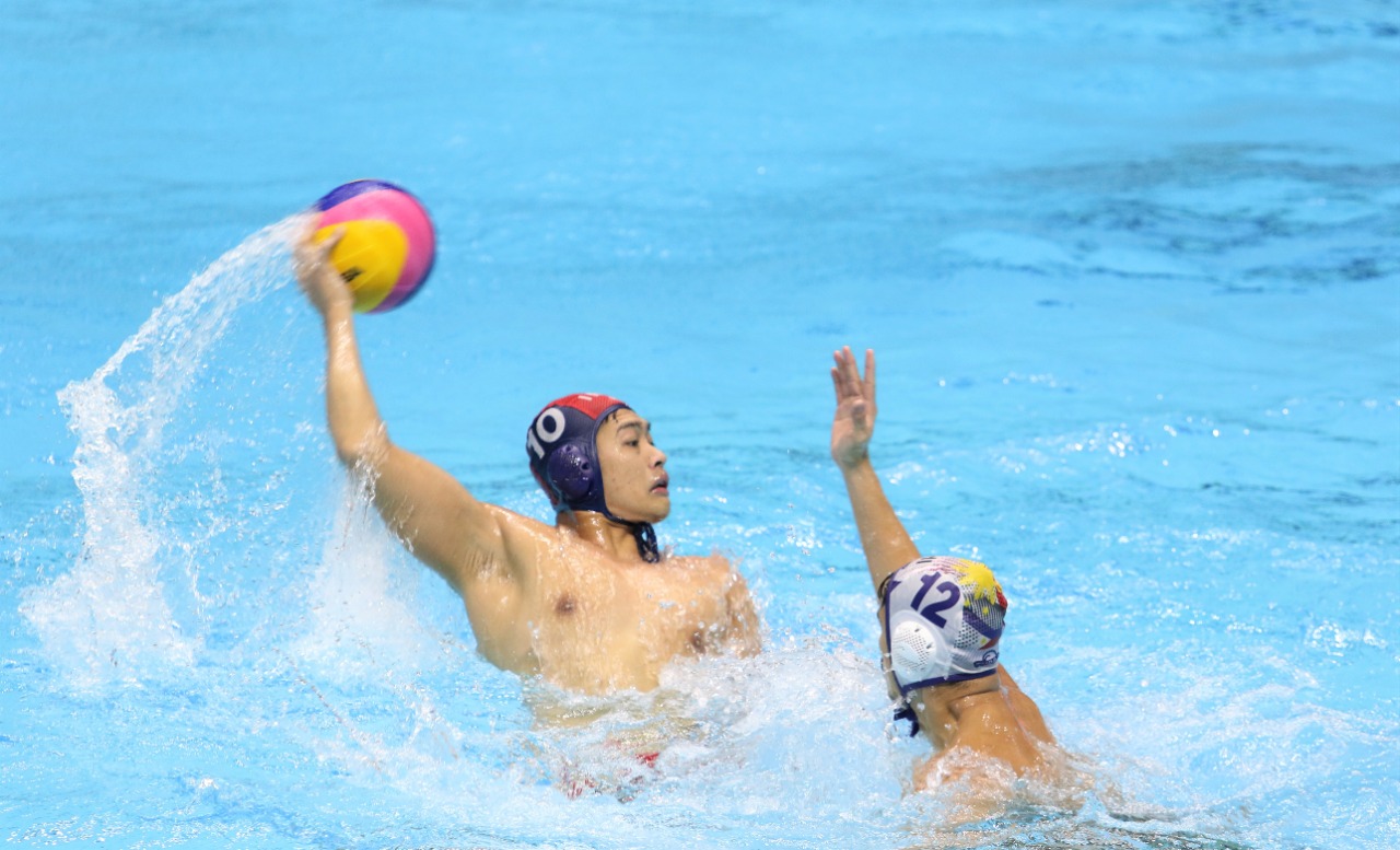 Pemain polo air Indonesia Ridjkie Mulia berusaha menembakkan  bola ke pertahanan Filipina