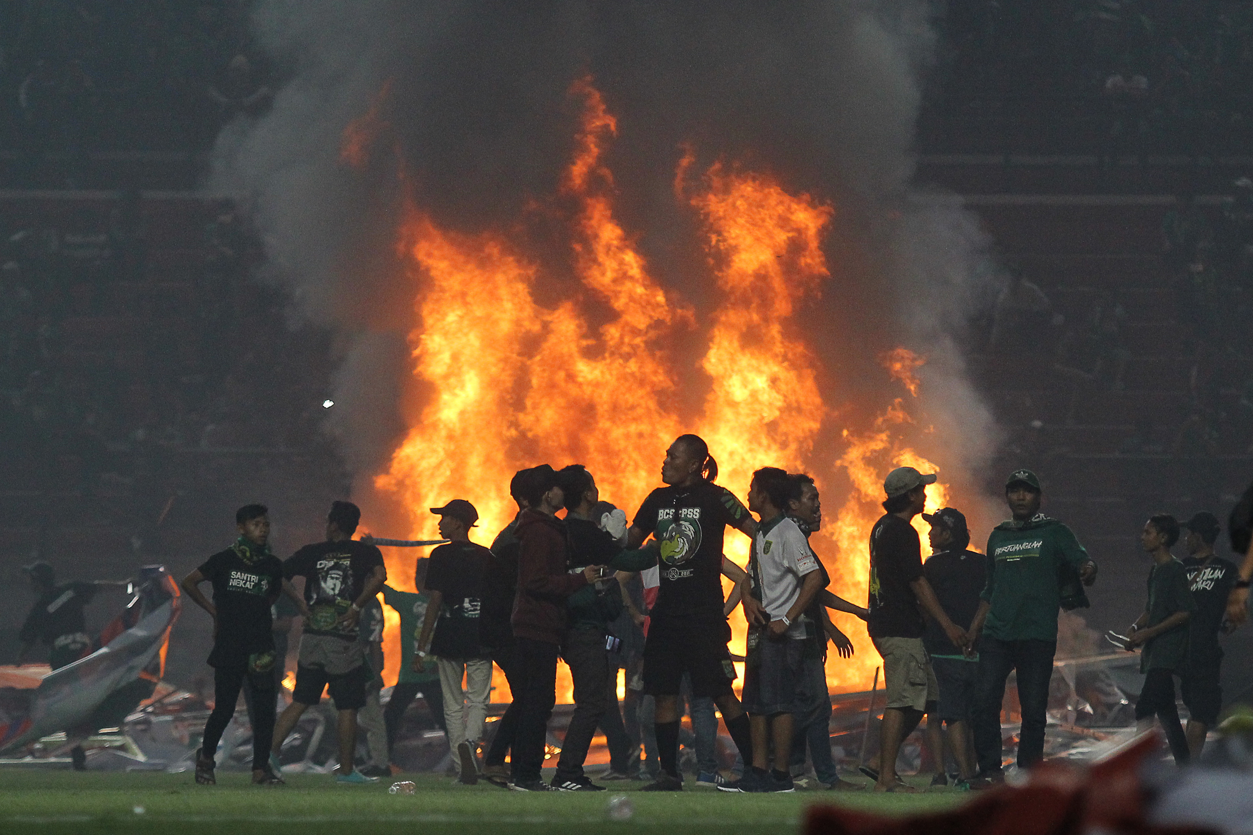 Suporter Persebaya membakar papan sponsor usai pertandingan Liga 1 2019 antara Persebaya dan PSS Sleman di Stadion Gelora Bung Tomo.