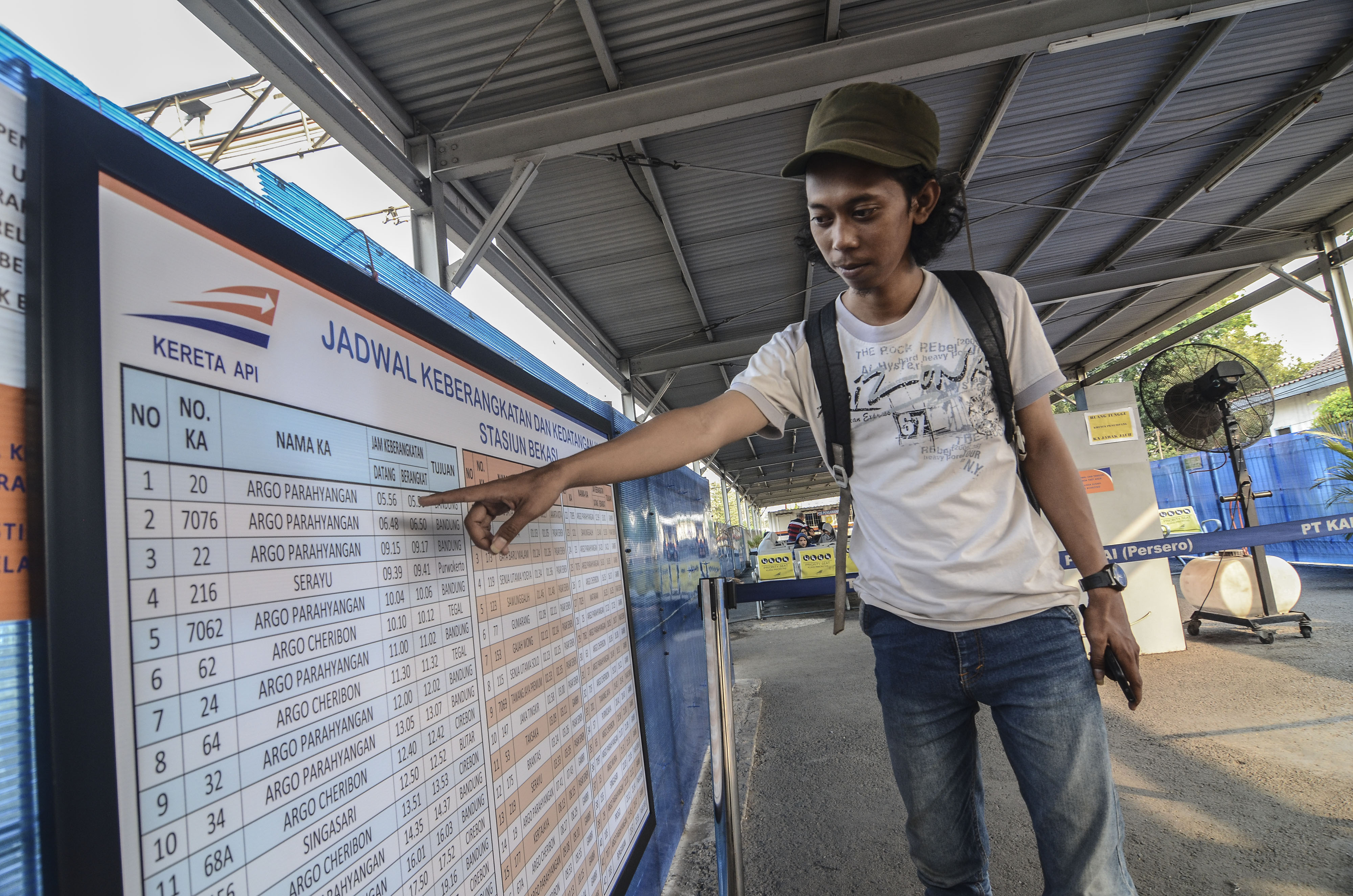Penumpang menunjuk jadwal keberangkatan Kereta Api (KA) jarak Jauh di Stasiun Bekasi, Jawa Barat.