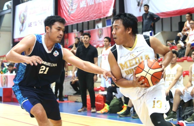 Pemain tim basket Media Grup (kanan) berusaha mempertahankan bola.