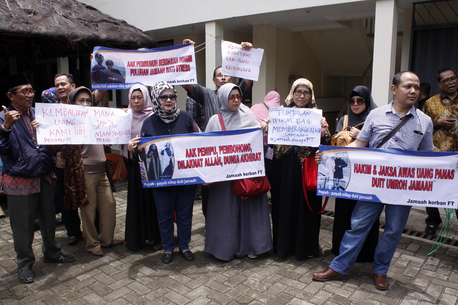 Calon jemaah umrah First Travel membentangkan spanduk kekecewaan saat mengikuti sidang perdana kasus dugaan penipuan First Travel