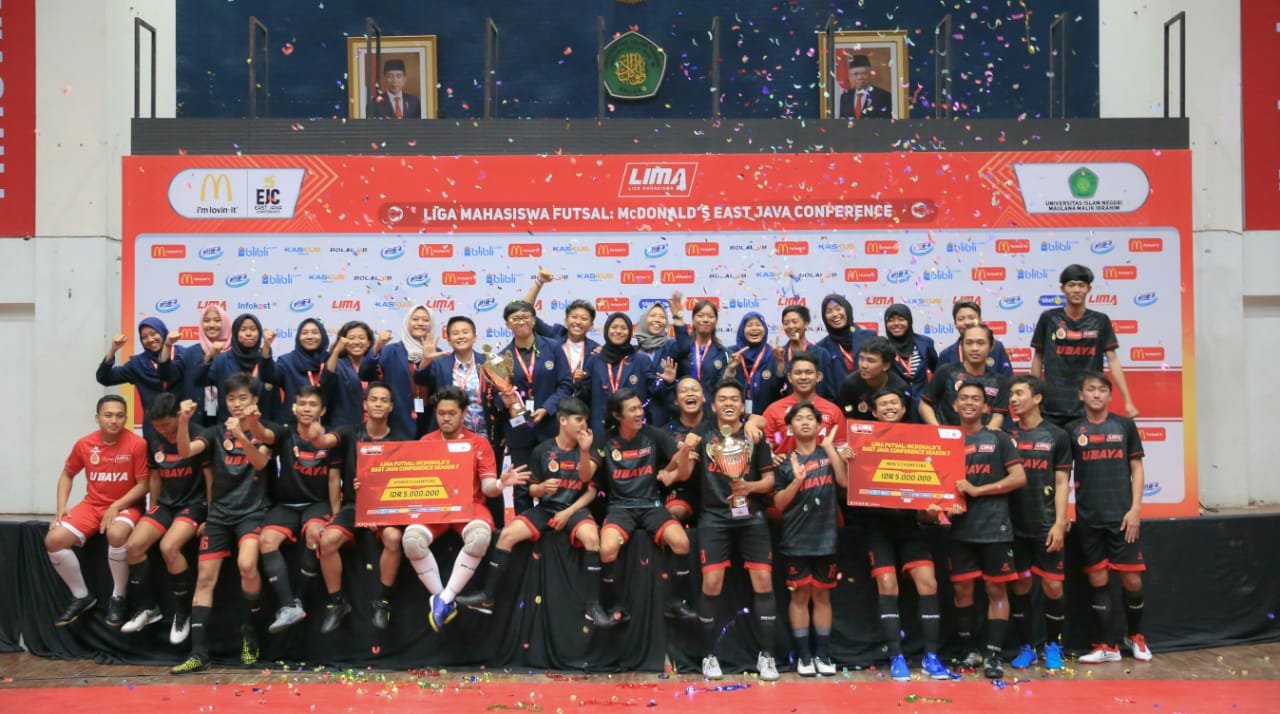 Para pemain tim Ubaya dan pelatih merayakan kesuksesan mereka menjadi juara.