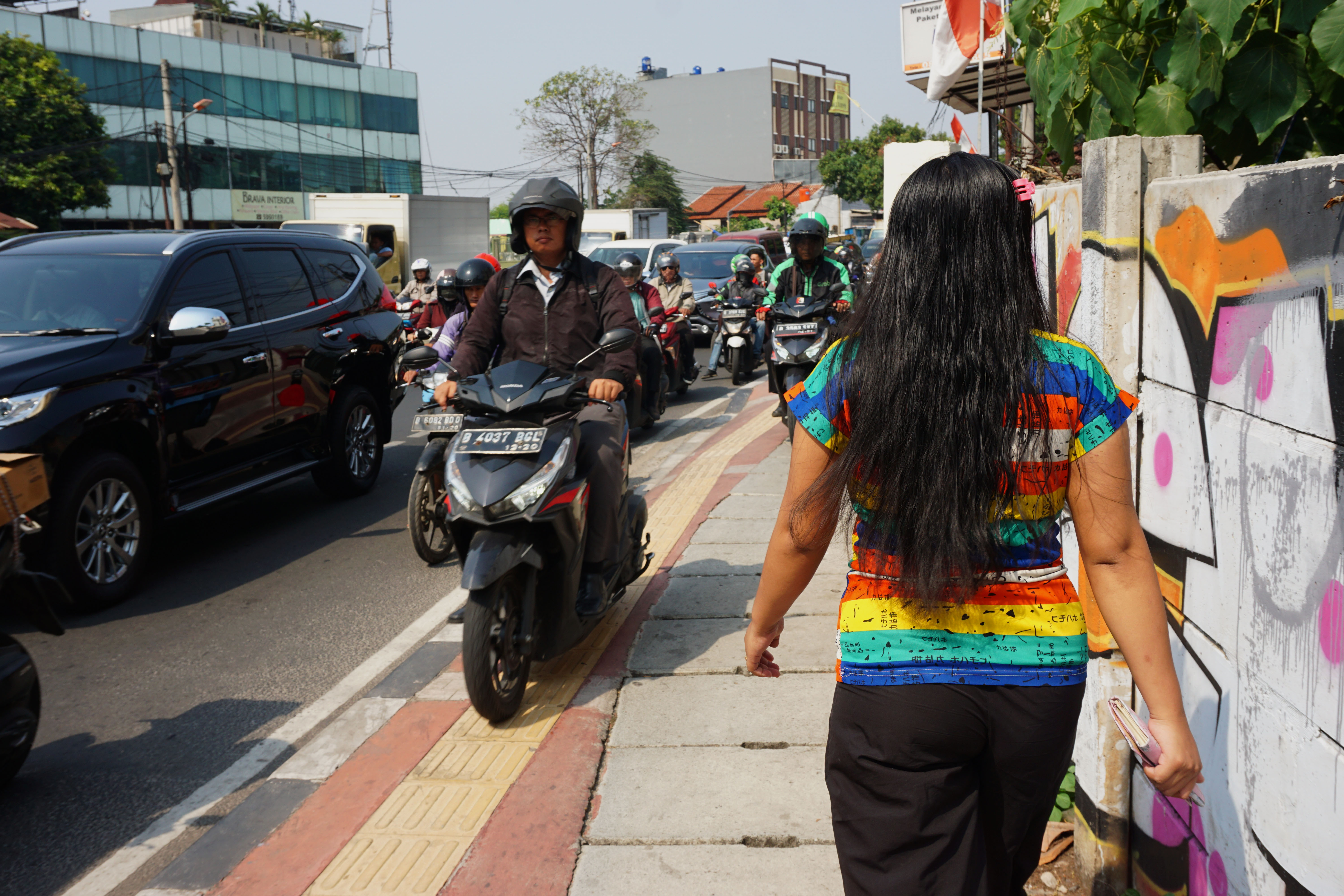 engendara sepeda motor melintas di atas trotoar pejalan kaki di Jalan Joglo Raya, Jakarta Barat. 