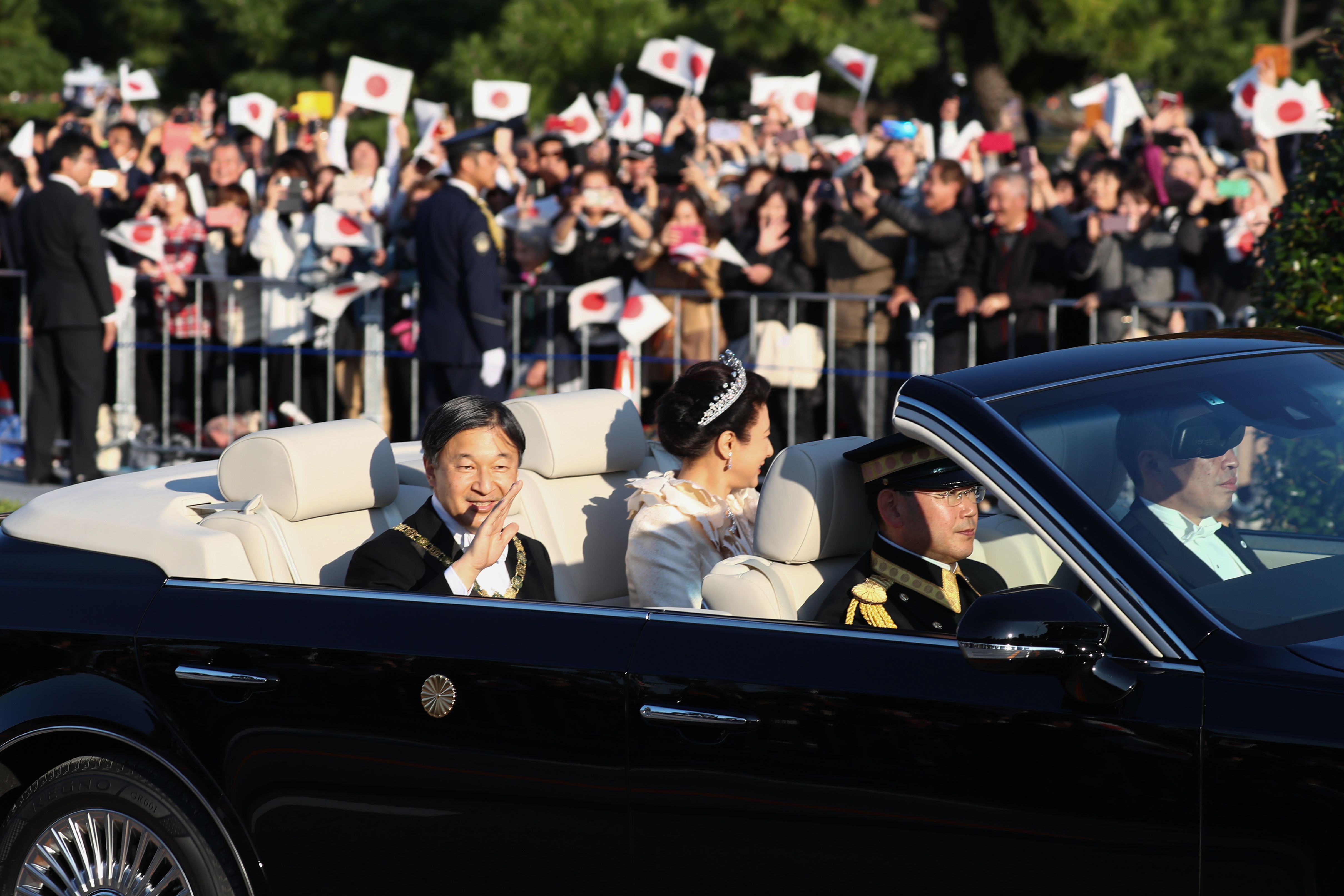 Kaisar Jepang Naruhito dan istrinya Masako melambaikan tangan ke arah warga saat melakukan parade di Tokyo.