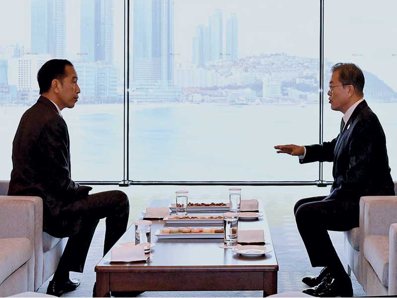 Presiden Joko Widodo berbincang dengan Presiden Korea Selatan Moon Jae-in di sela-sela ASEAN-Republic of Korea (RoK) CEO Summit di Busan.