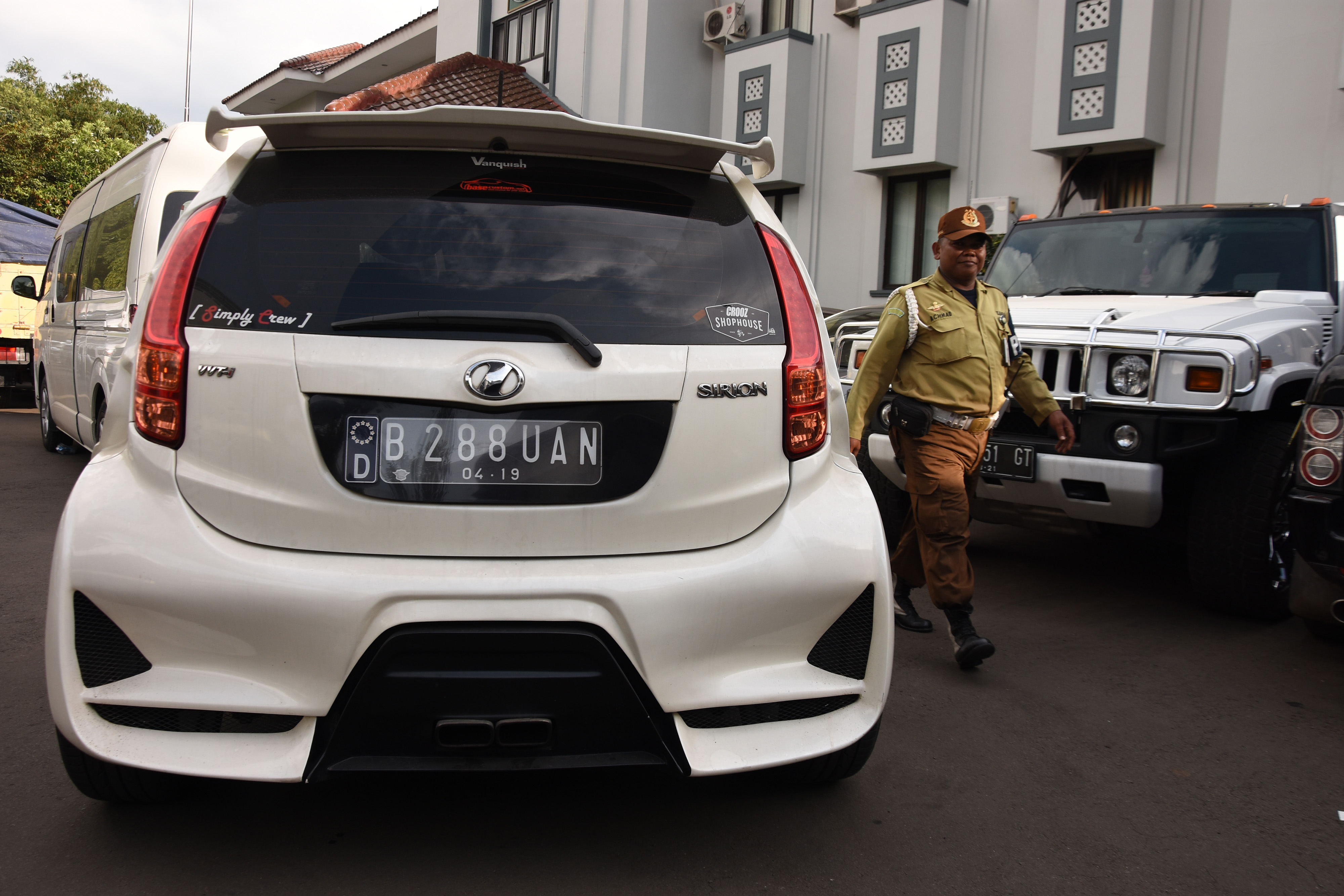 Petugas melintas diantara mobil sitaan aset First Travel 