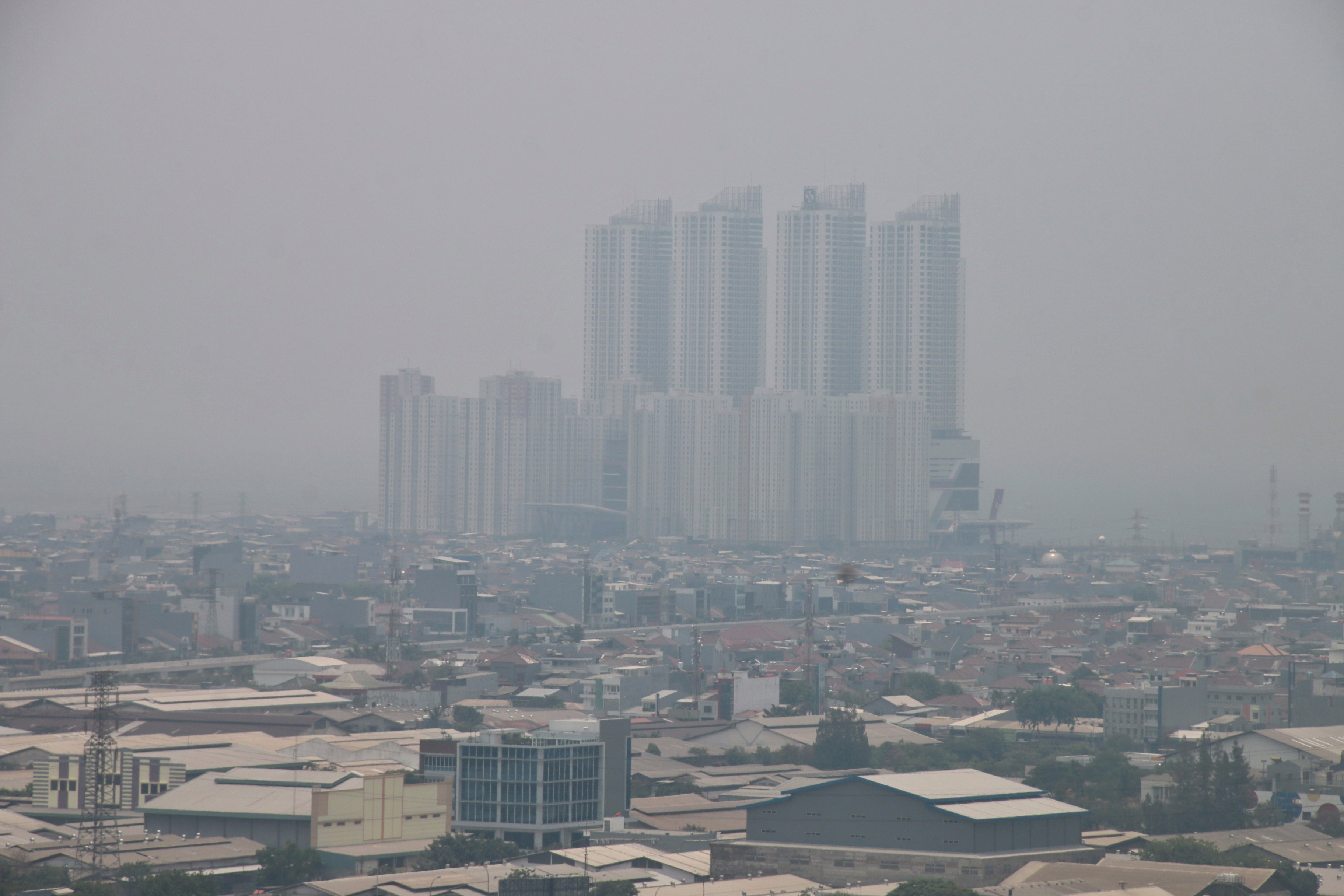 Gedung bertingkat tersamar kabut polusi udara di Jakarta, Selasa (8/10/2019). 