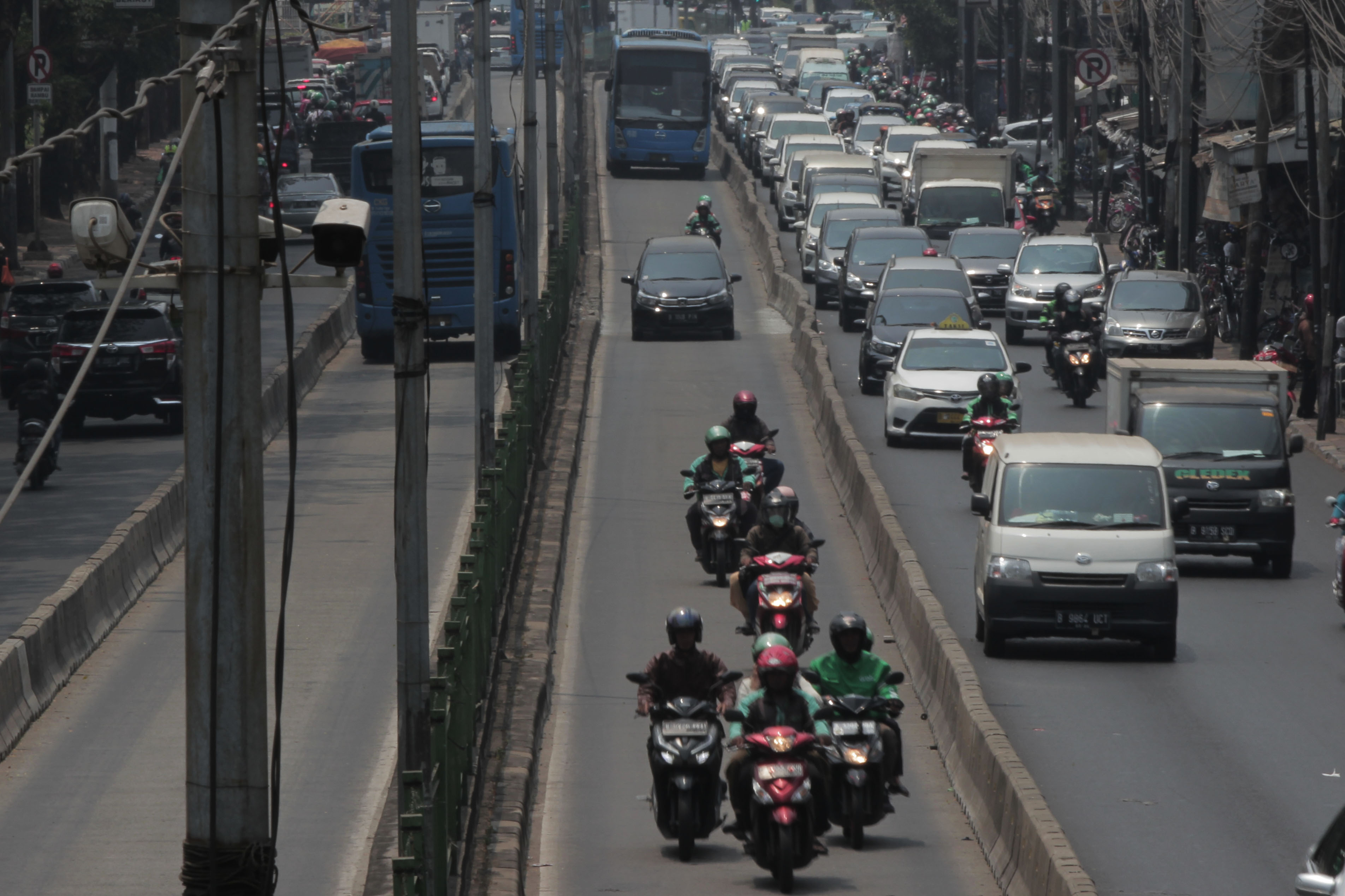 Sejumlah pengemudi sepeda motor masuk ke jalur bus Trans-Jakarta di Pasar Rumput