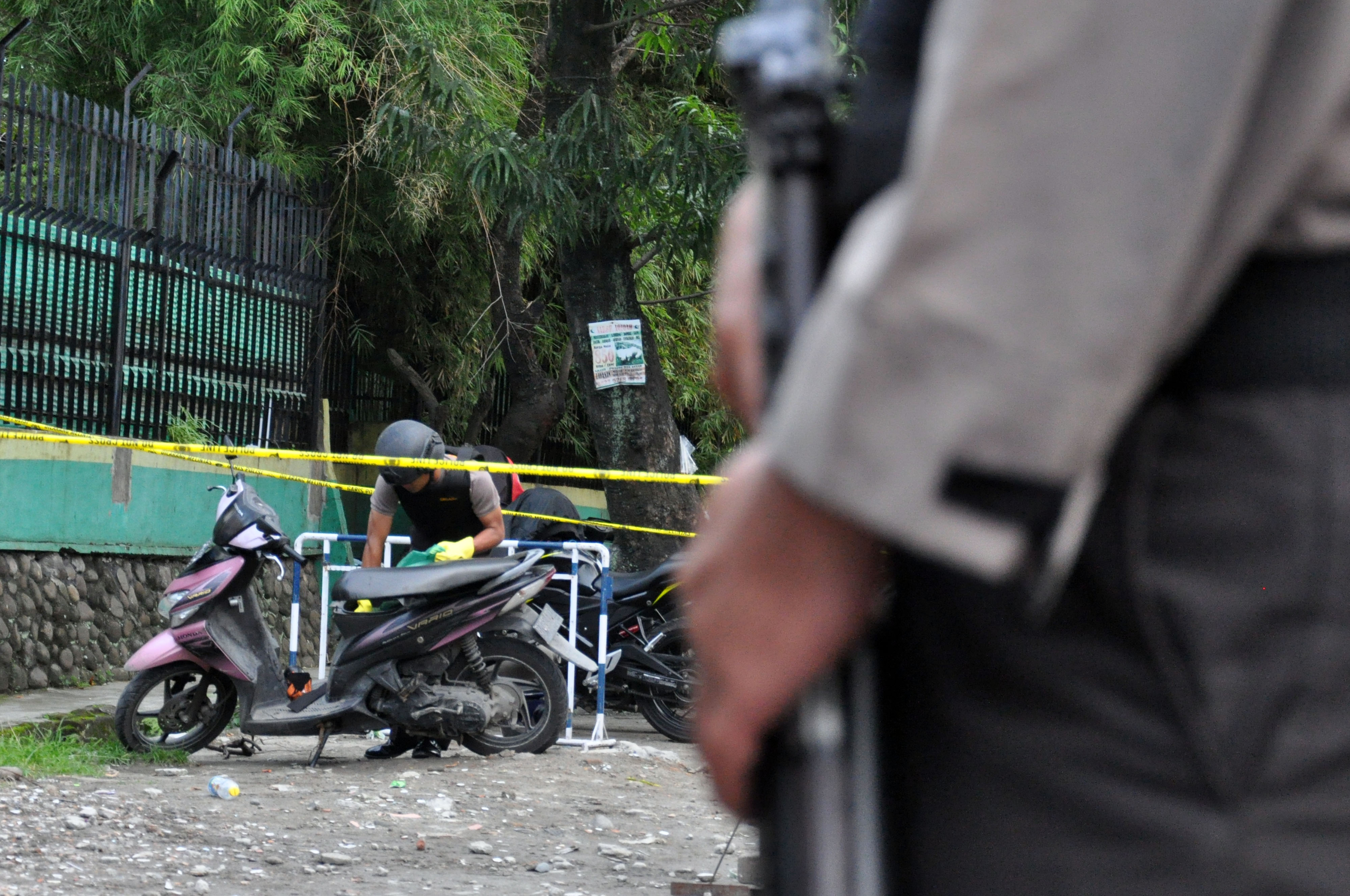 Personel kepolisian memeriksa sepeda motor terduga pelaku bunuh diri di Mapolresta Medan