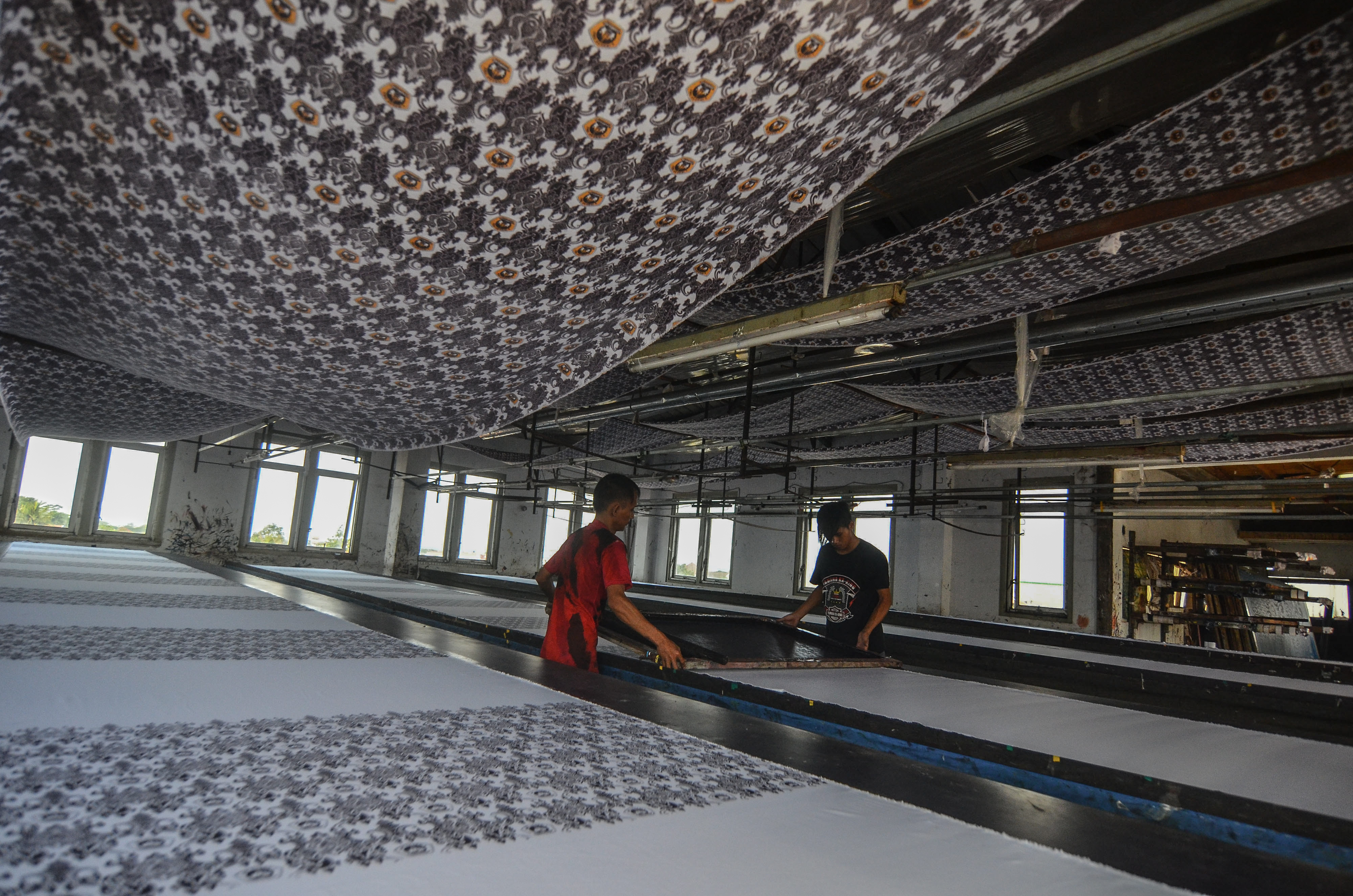  Pekerja memproduksi batik printing dengan produksi 1.000 meter per hari di Rumah Tekstil Cineuheul, Kota Tasikmalaya, Jawa Barat,