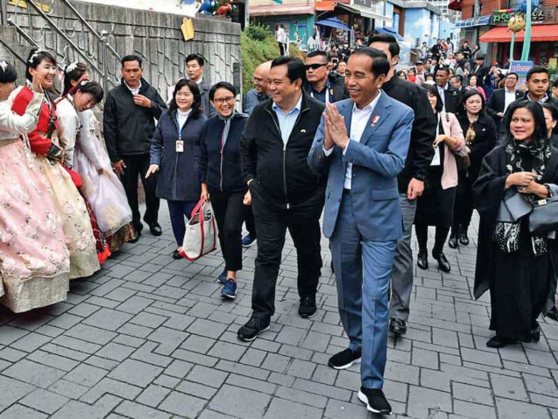 Presiden Joko Widodo dan Ibu Negara Iriana Joko Widodo memberikan salam saat meninjau Gamcheon Culture Village di Busan, Korea Selatan.