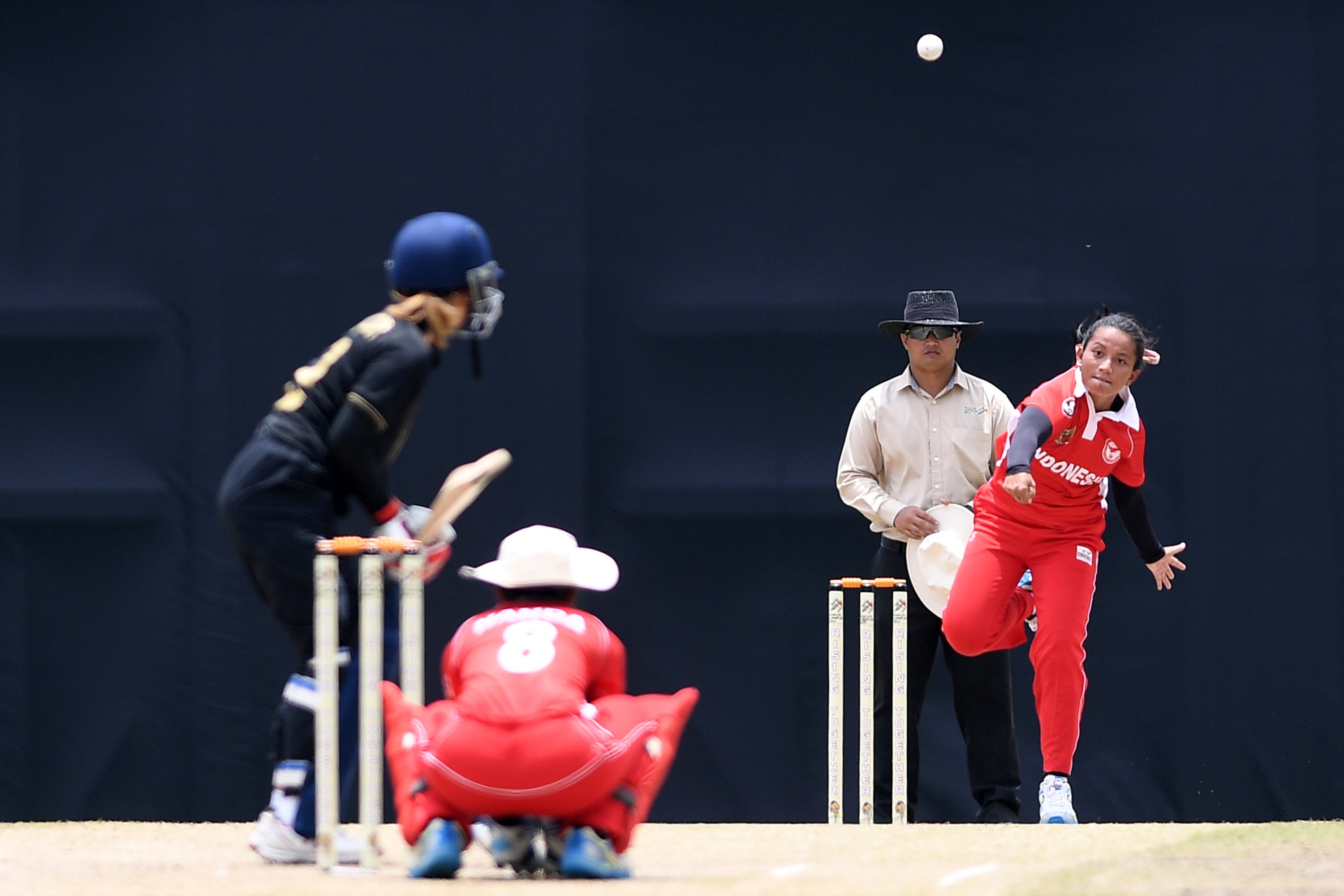Bowler putri Indonesia Taskia Hanum (kanan) melemparkan bola ke arah batswoman Thailand dalam final kriket putri SEA Games XXIX