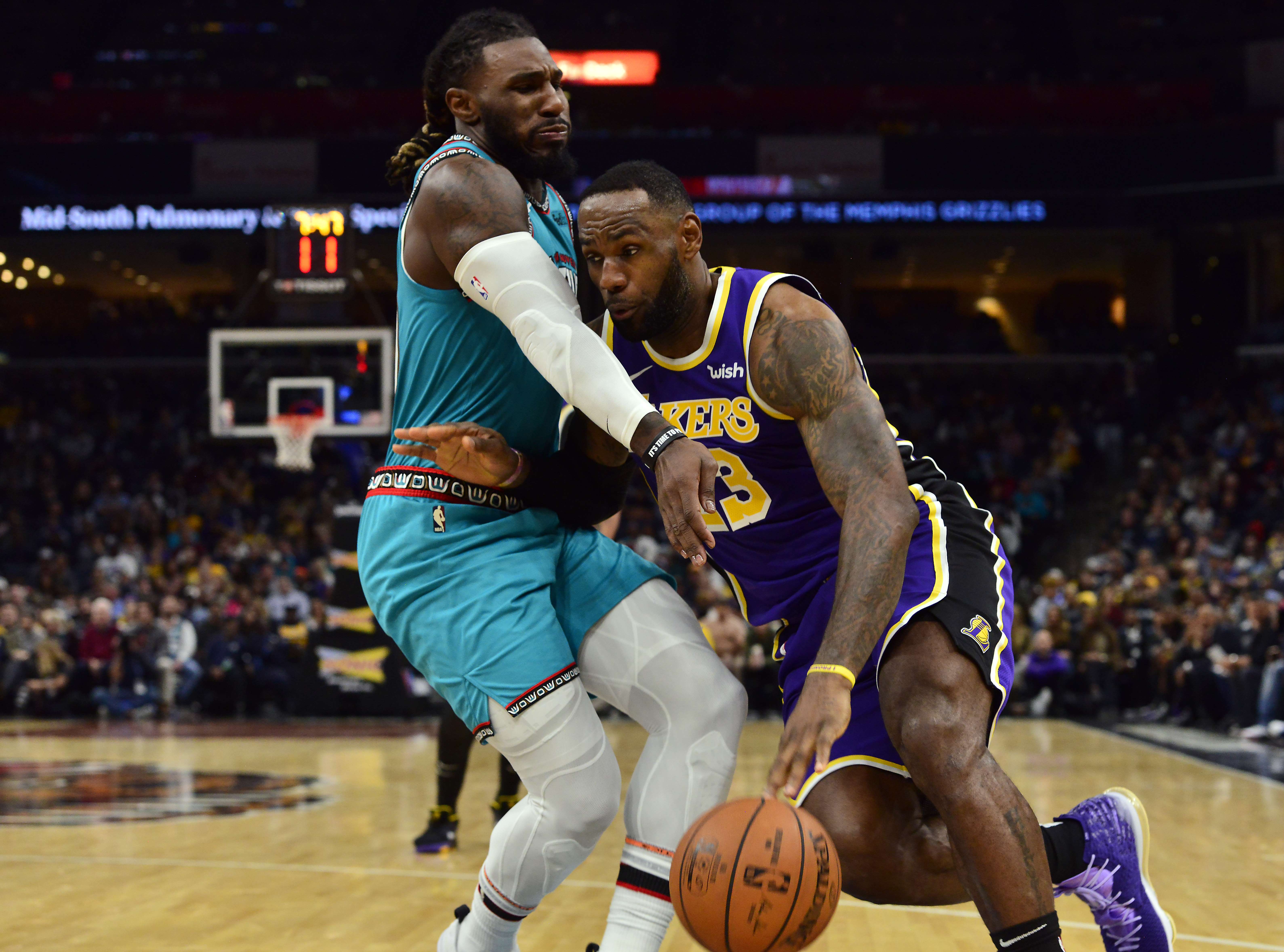 Bintang Los Angeles Lakers LeBron James (kanan) berusaha melewati hadangan pemain Grizzlies Jae Crowder.