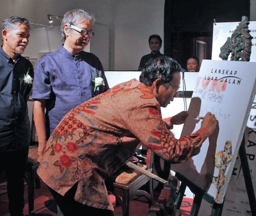PAMERAN LUKISAN: Menko Polhukam Mahfud Md menandatangani lukisan saat membuka pameran lukisan Lanskap Luar Dalam karya Butet Kartaredjasa