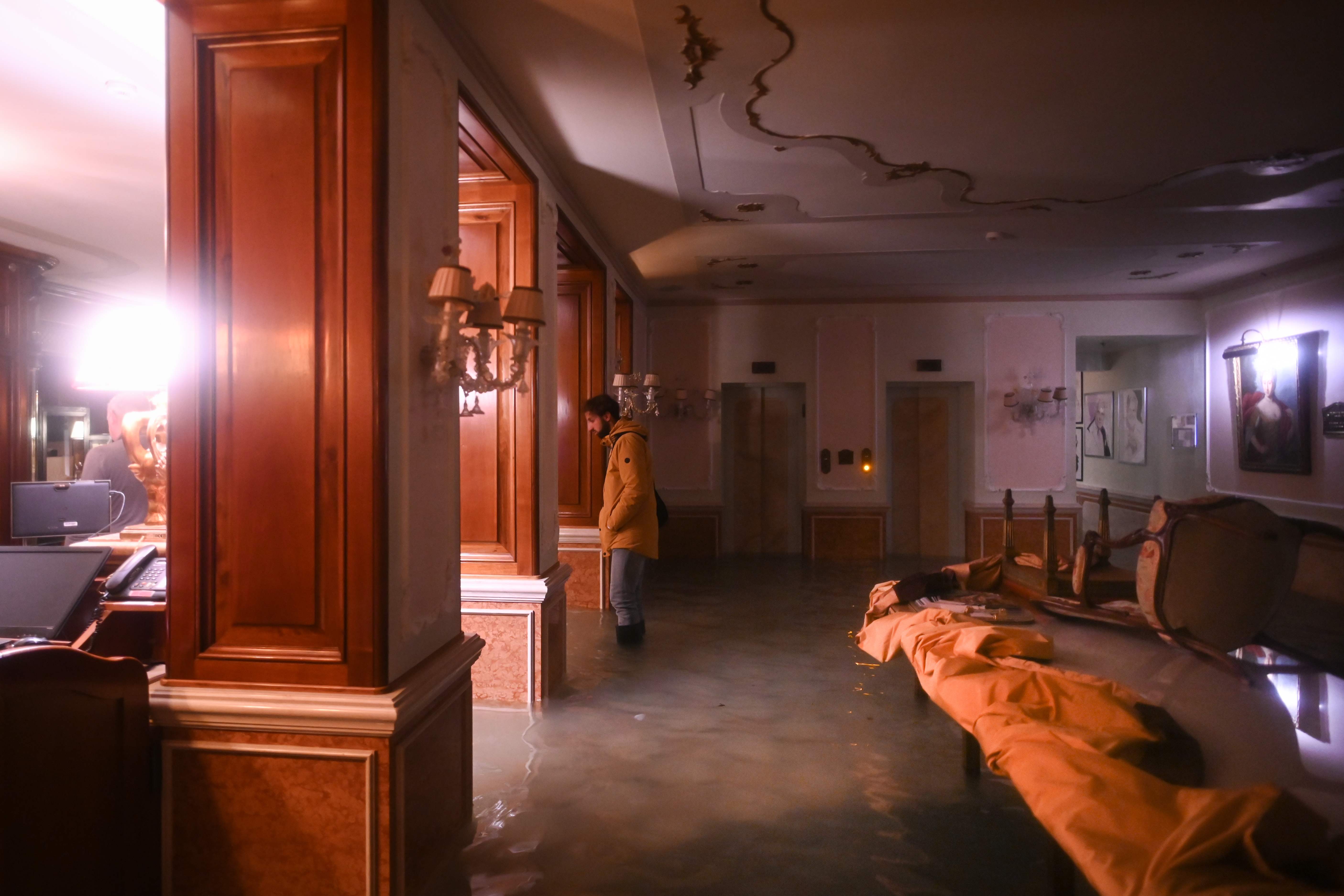 Seorang pria berdiri di tengah air banjir di Gritti Palace, Venesia, Italia.