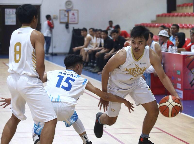 Pemain tim basket Media Group (kanan) berusaha melawan pemain lawan. 