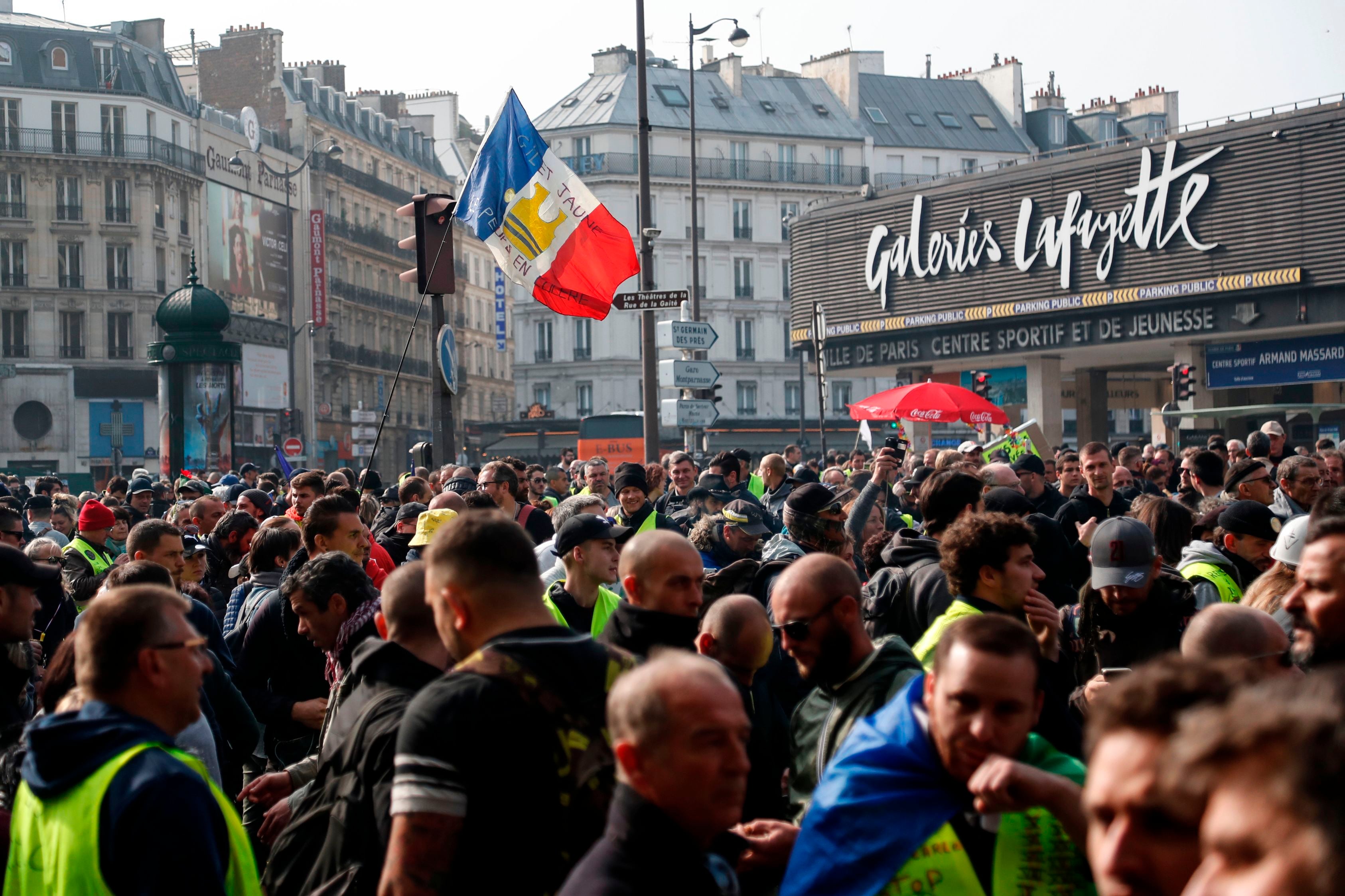 Pedemo Rompi Kuning berkumpul di depan pusat perbelanjaan ternama di Paris, Galeries Lafayette