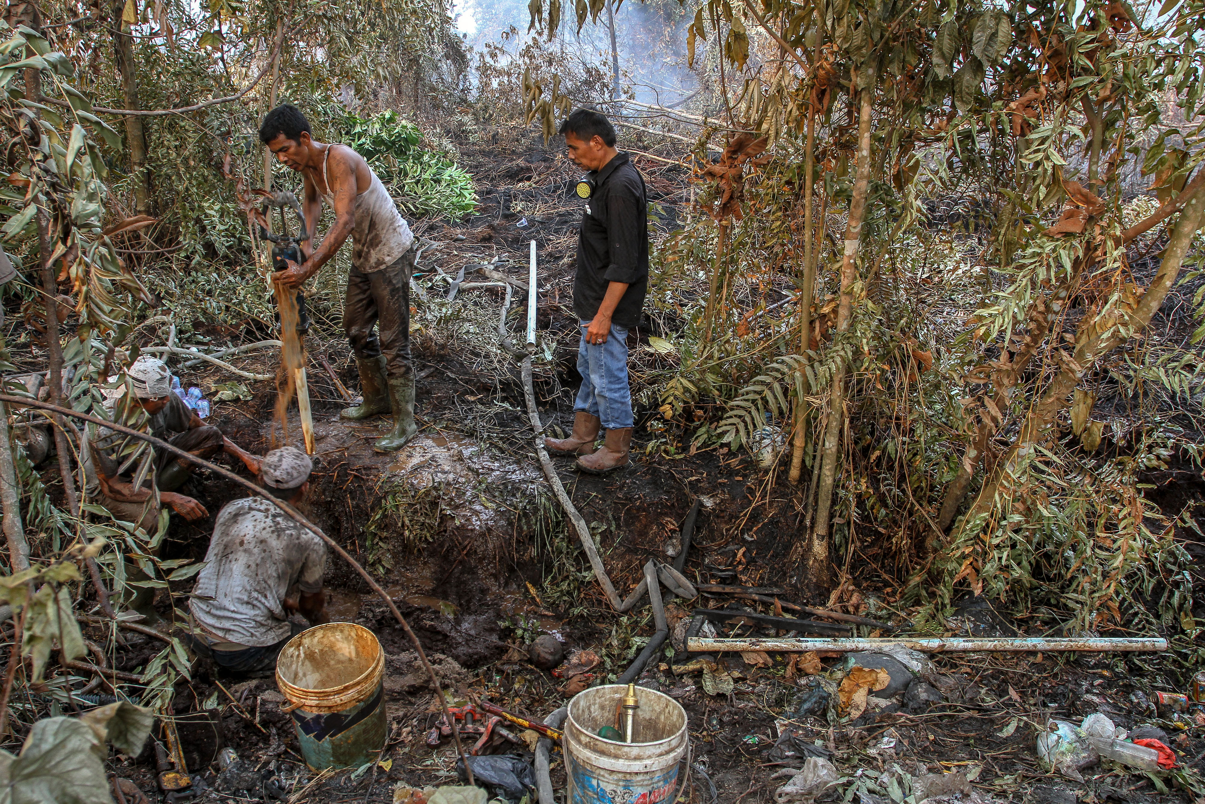 Sejumlah pekerja menggali tanah ketika membuat sumur bor di lokasi lahan gambut yang terbakar di Desa Rimbo Panjang, Kampar, Riau