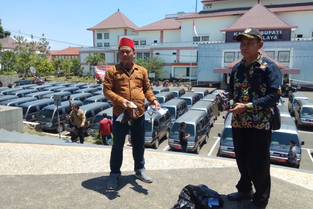 Ratusan mobil operasional kepala desa yang diparkir di kantor bupati karena dana desa tidak kunjung cair. 