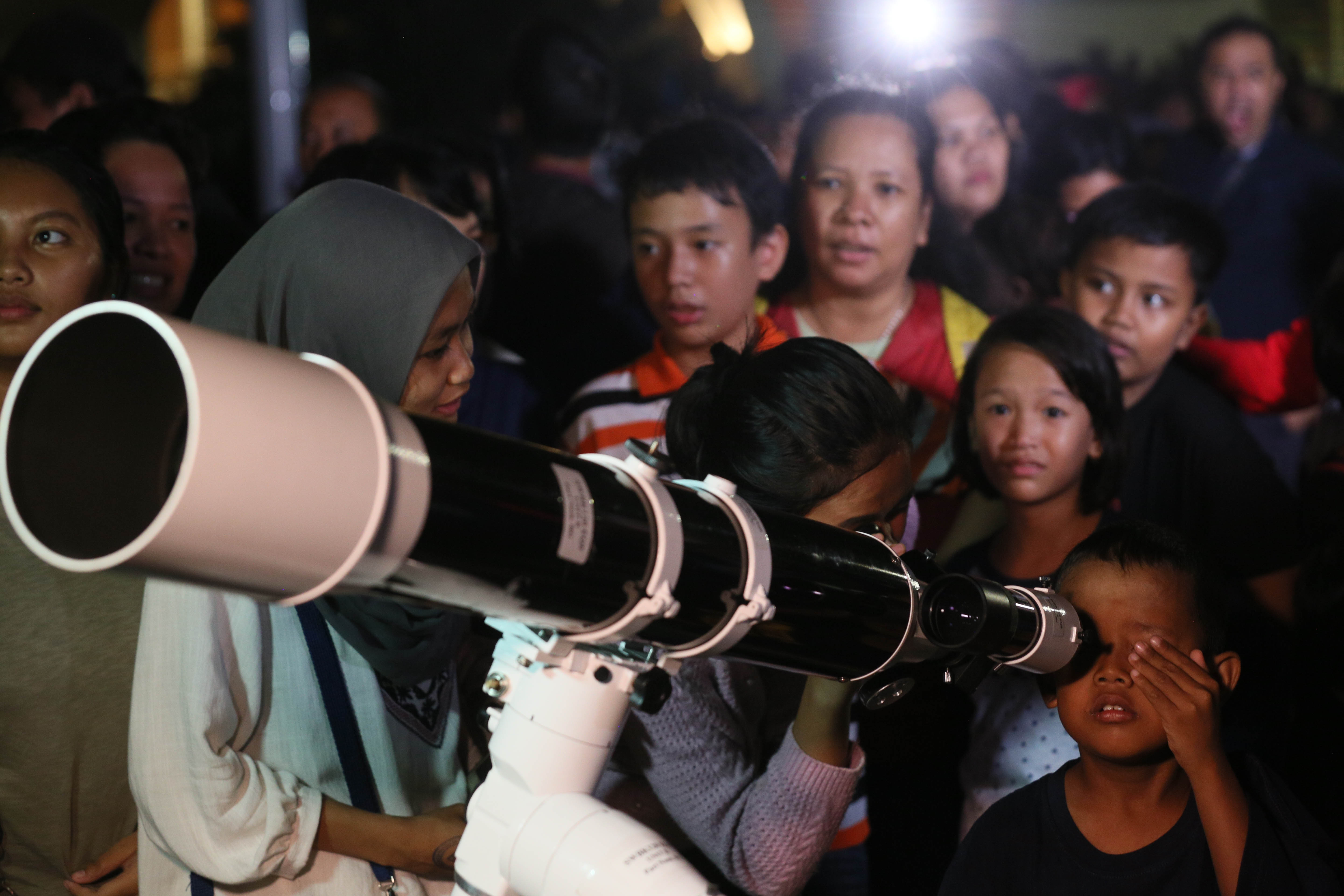 Warga mengamati benda langit menggunakan teropong di Planetarium Jakarta.