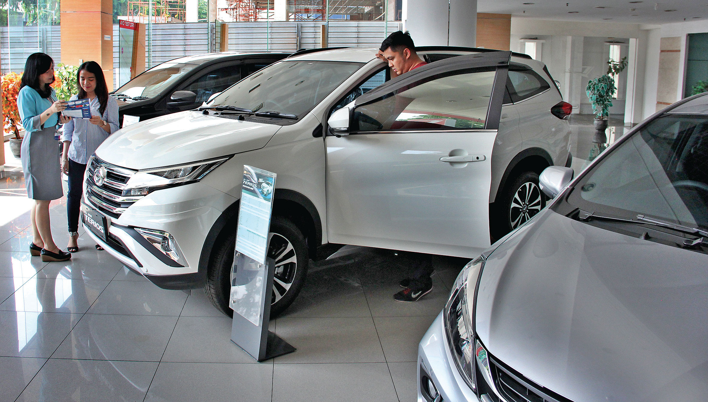 Konsumen mendapat penjelasan dari sales di showroom Daihatsu Sunter, Jakarta, Rabu (11/12).
