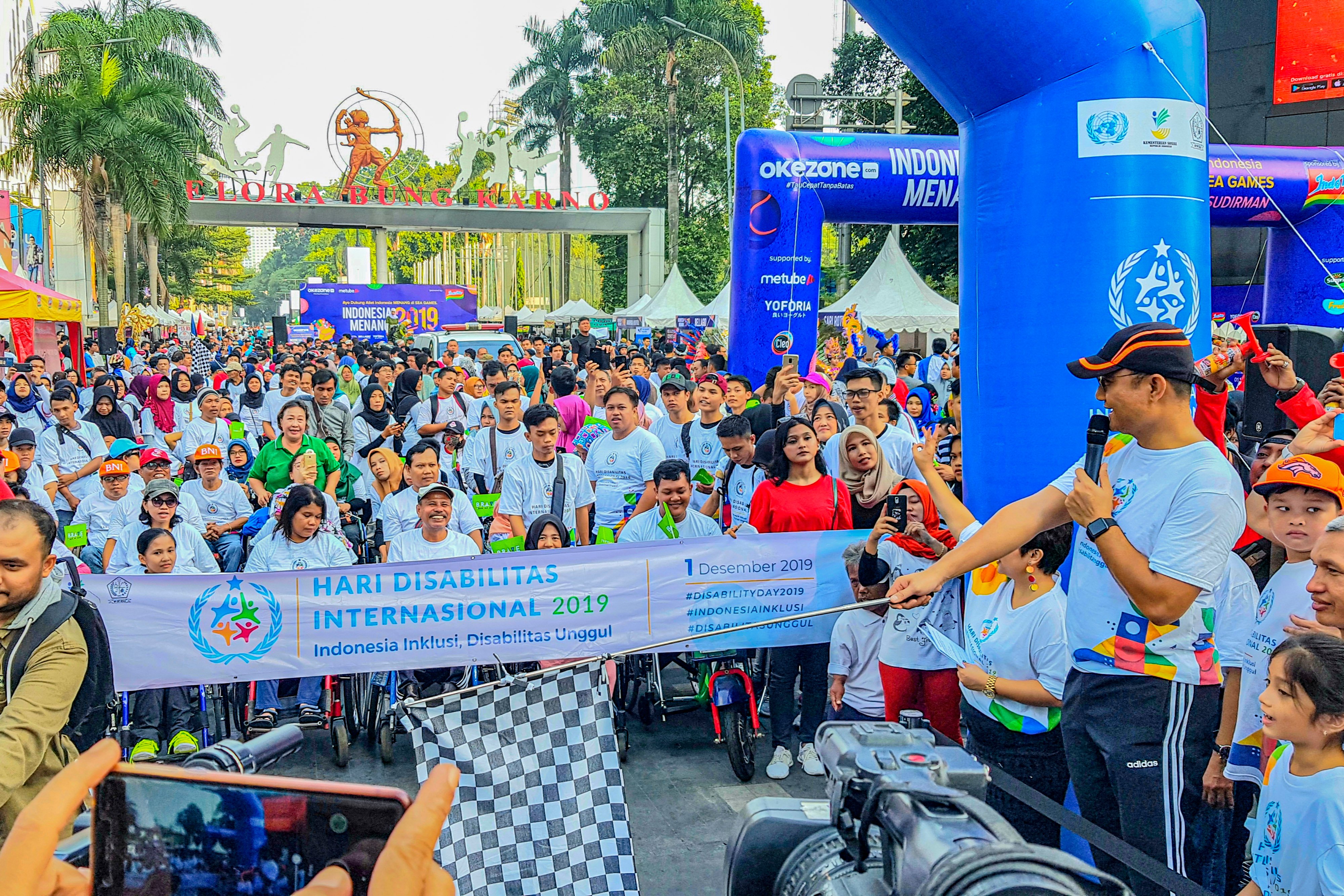 Menteri Sosial Juliari P. Batubara (kanan) bersiap melepas gerak jalan dalam rangka memperingati Hari Penyandang Disabilitas Internasional