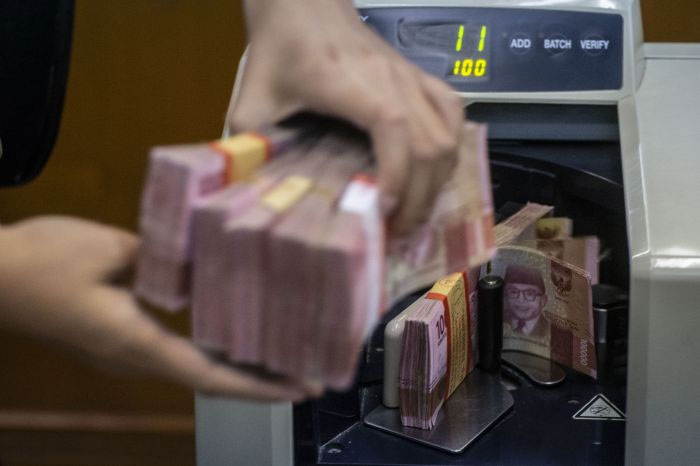  Petugas mengitung uang rupiah di salah satu gerai penukaran uang asing di Jakarta.