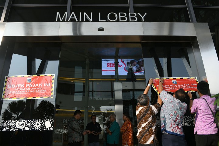 Pemasangan stiker dilakukan tepat di kaca pintu masuk Mall Bay Walk Pluit, Jakarta Utara.
