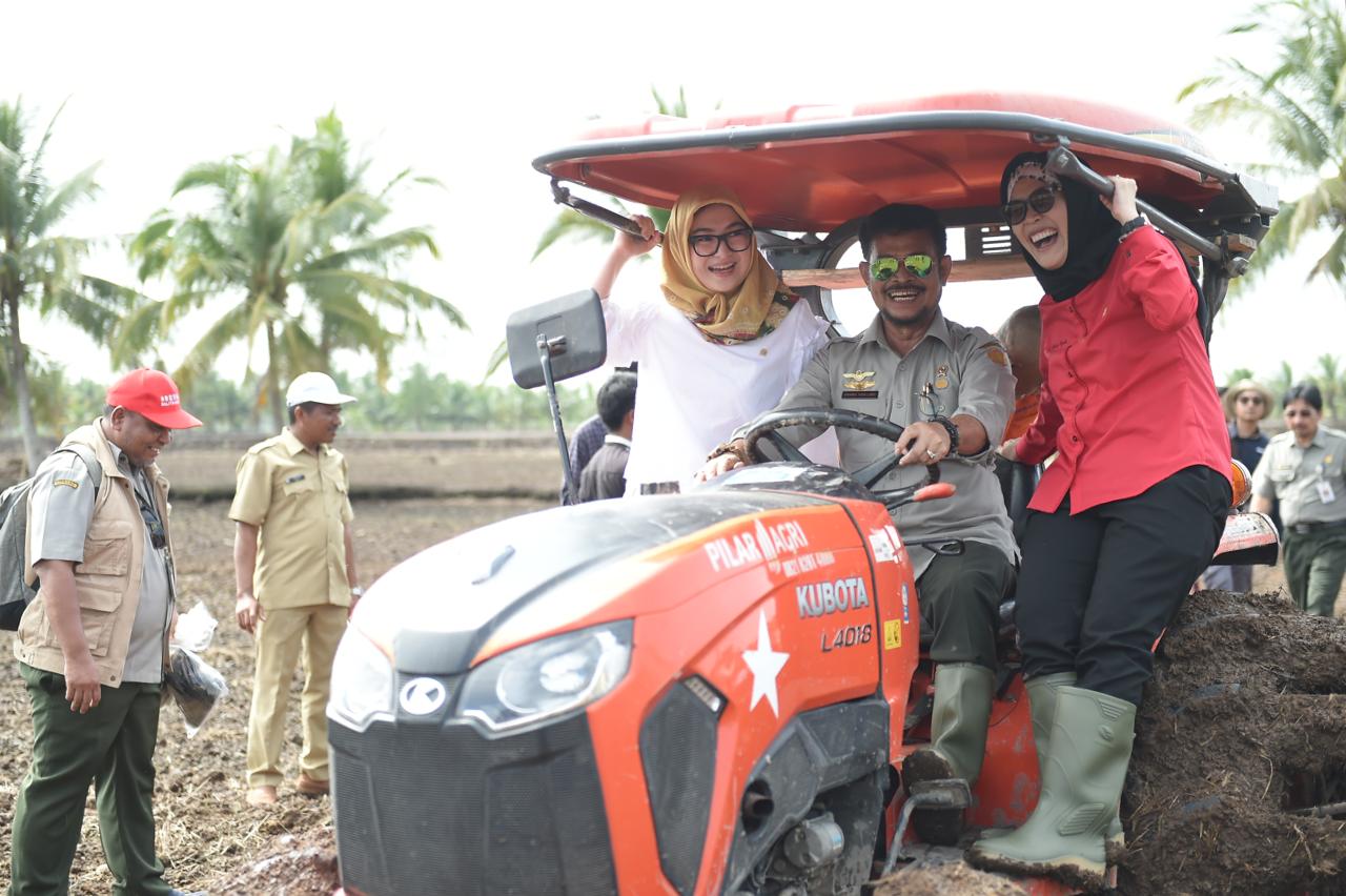 Menteri Pertanian Syahrul Yasin Limpo (tengah) bersama anggota Komisi IV DPR Riezky Aprilia (kiri) menaiki traktor.
