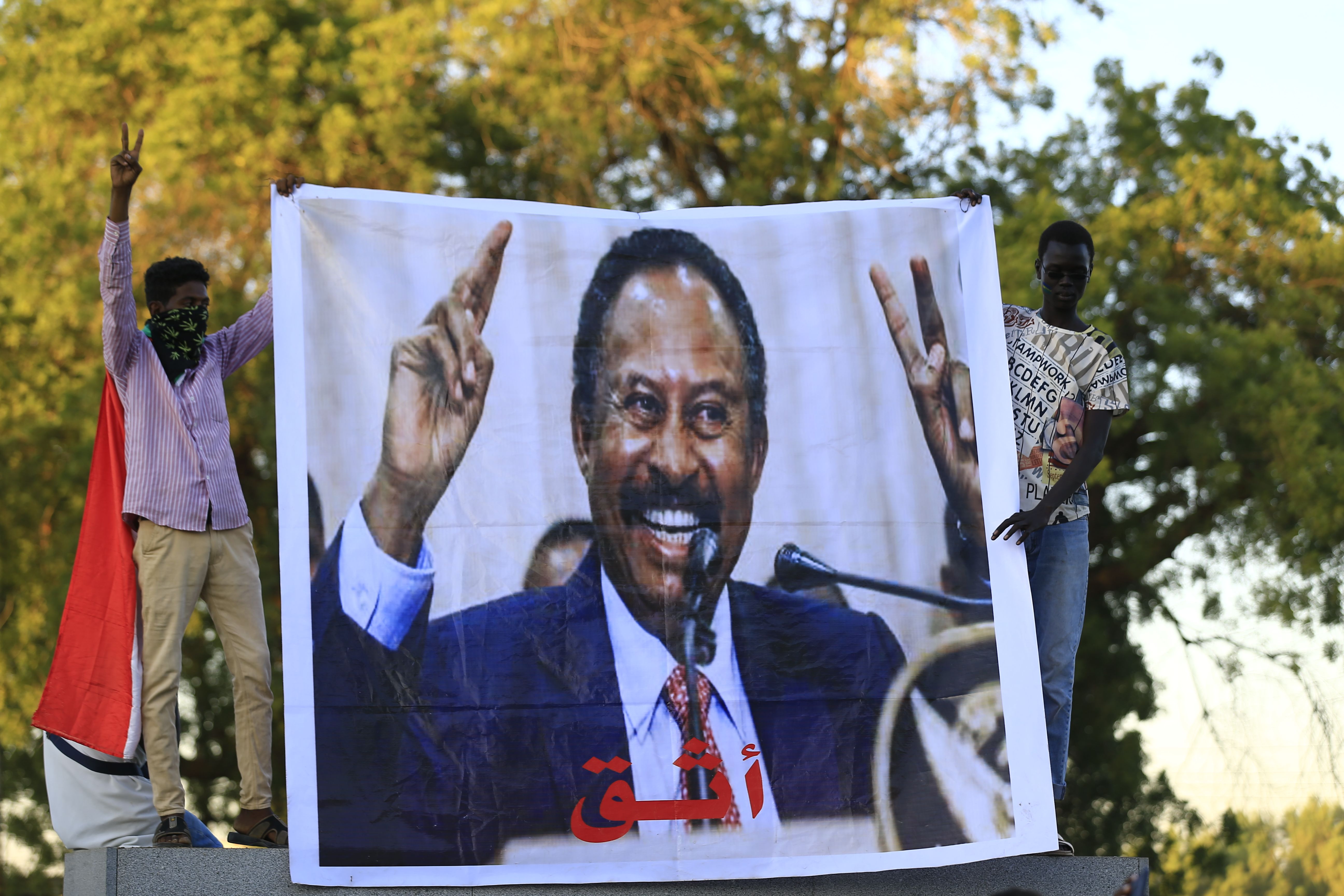 Warga Sudan membentangkan gambar PM Sudan Abdullah Hamdock saat merayakan penggulingan Omar al-Bashir di Khartoum, Rabu (25/12). 
