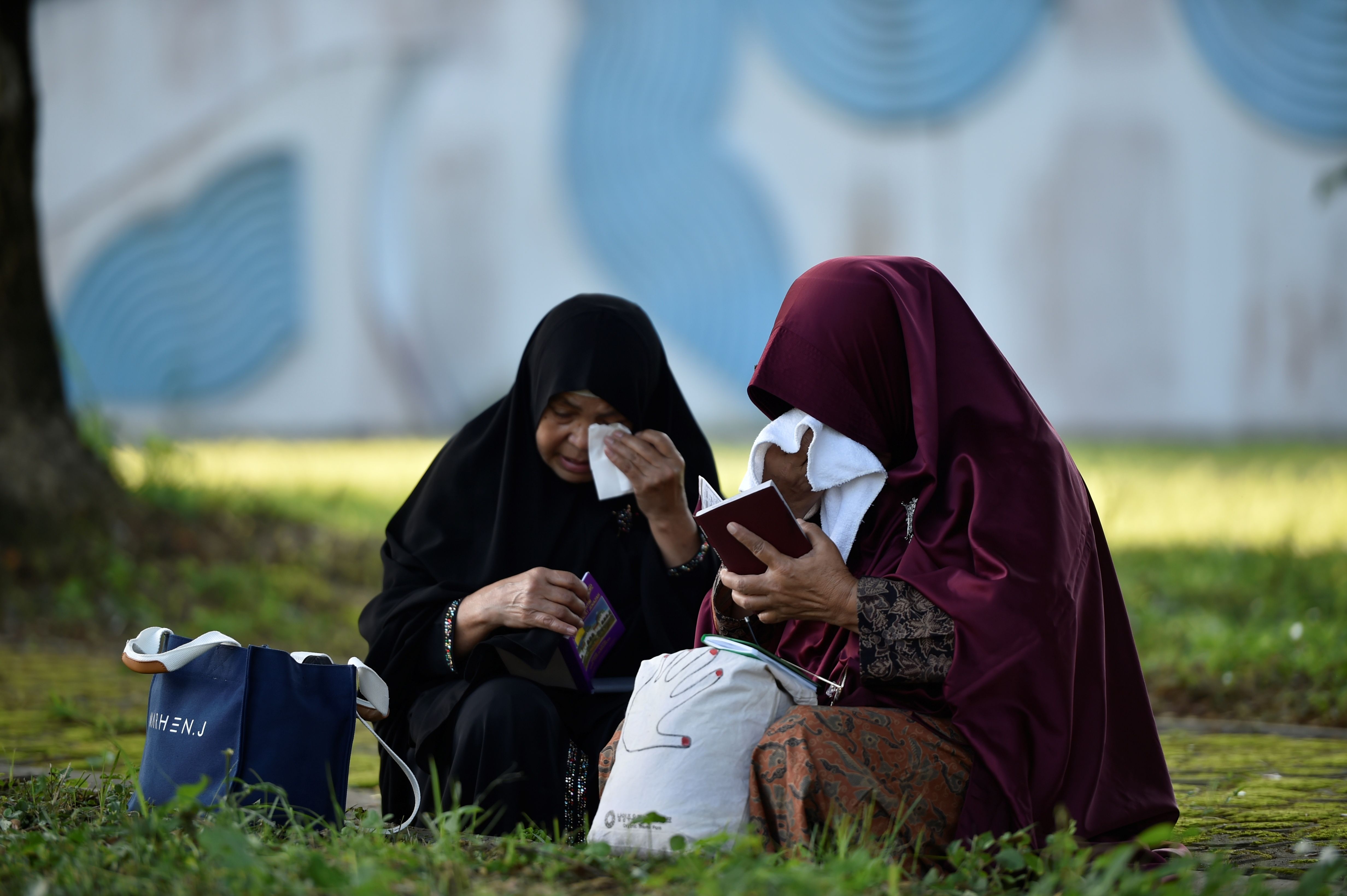 Nurhayati (kanan), menangis di kuburan massal korban tsunami Aceh di Desa Siron, Aceh, Kamis (26/12).