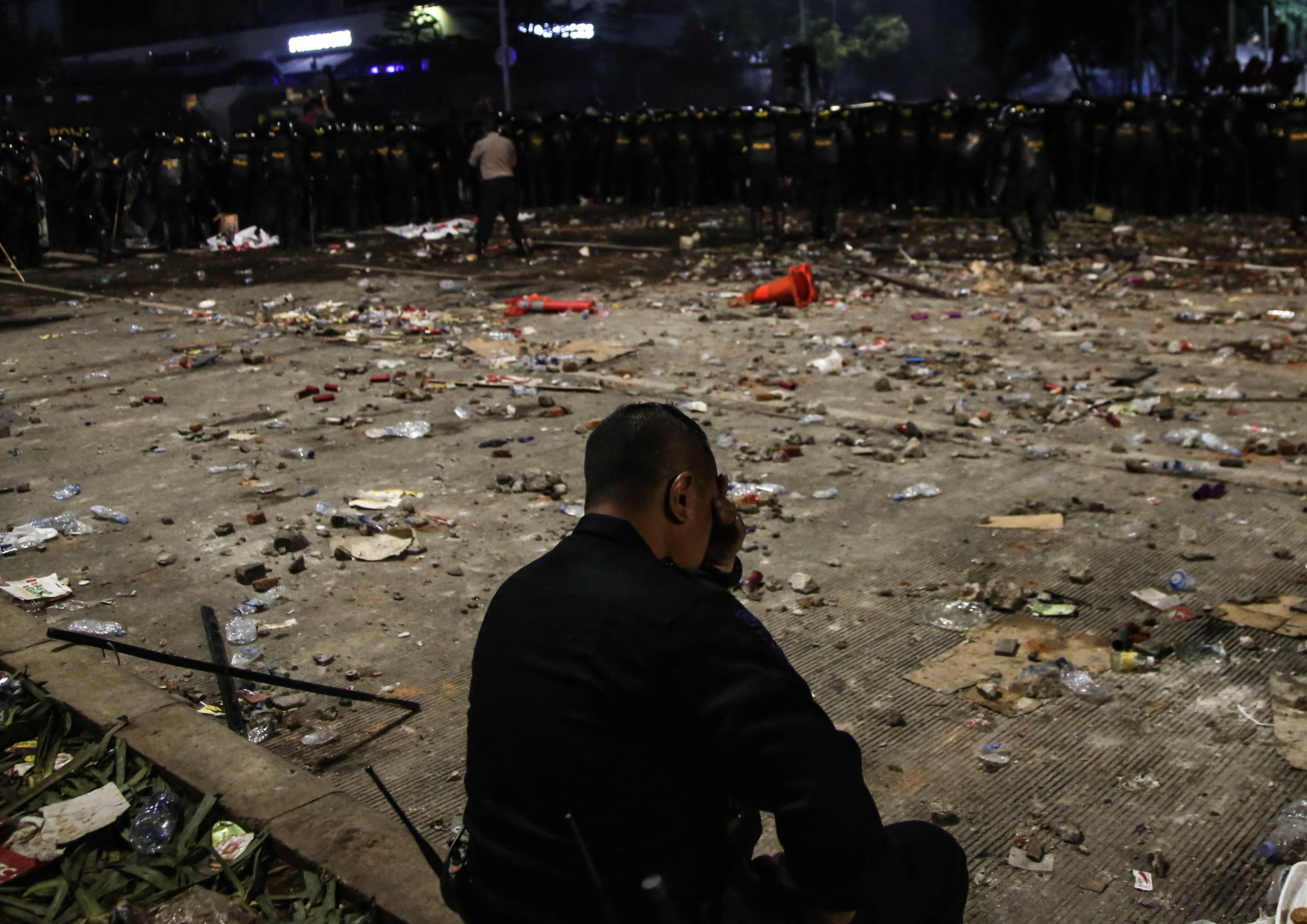 Personel polisi istirahat di pengamanan aksi di depan gedung Bawaslu, Jakarta, Rabu (22/5/2019) malam. 