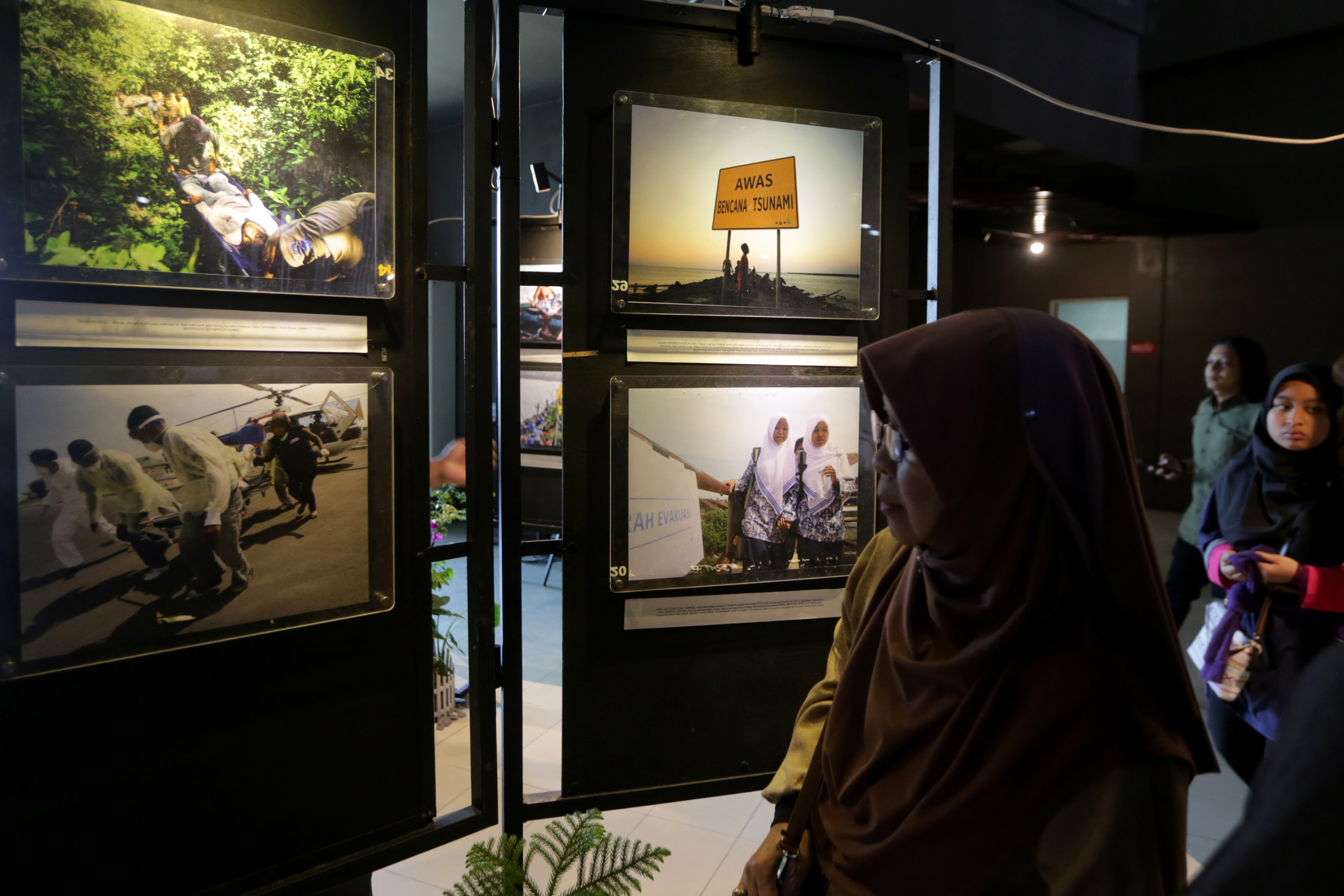 Pengunjung menyaksikan pameran foto kebencanaan karya jurnalis foto dari berbagai media di Museum Tsunami Banda Aceh. 