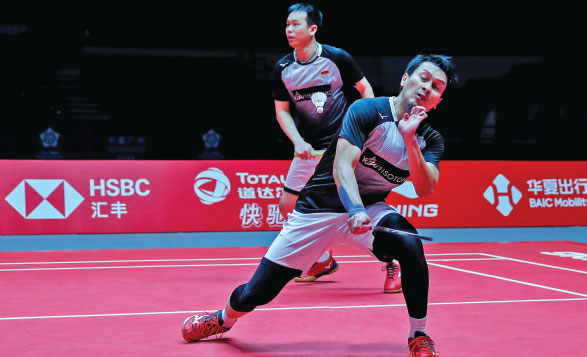 Mohammad Ahsan (depan) yang berpasangan dengan Hendra Setiawan berusaha mengembalikan bola pukulan ganda Taiwan, Lee Yang/Wang Chi Lin,  