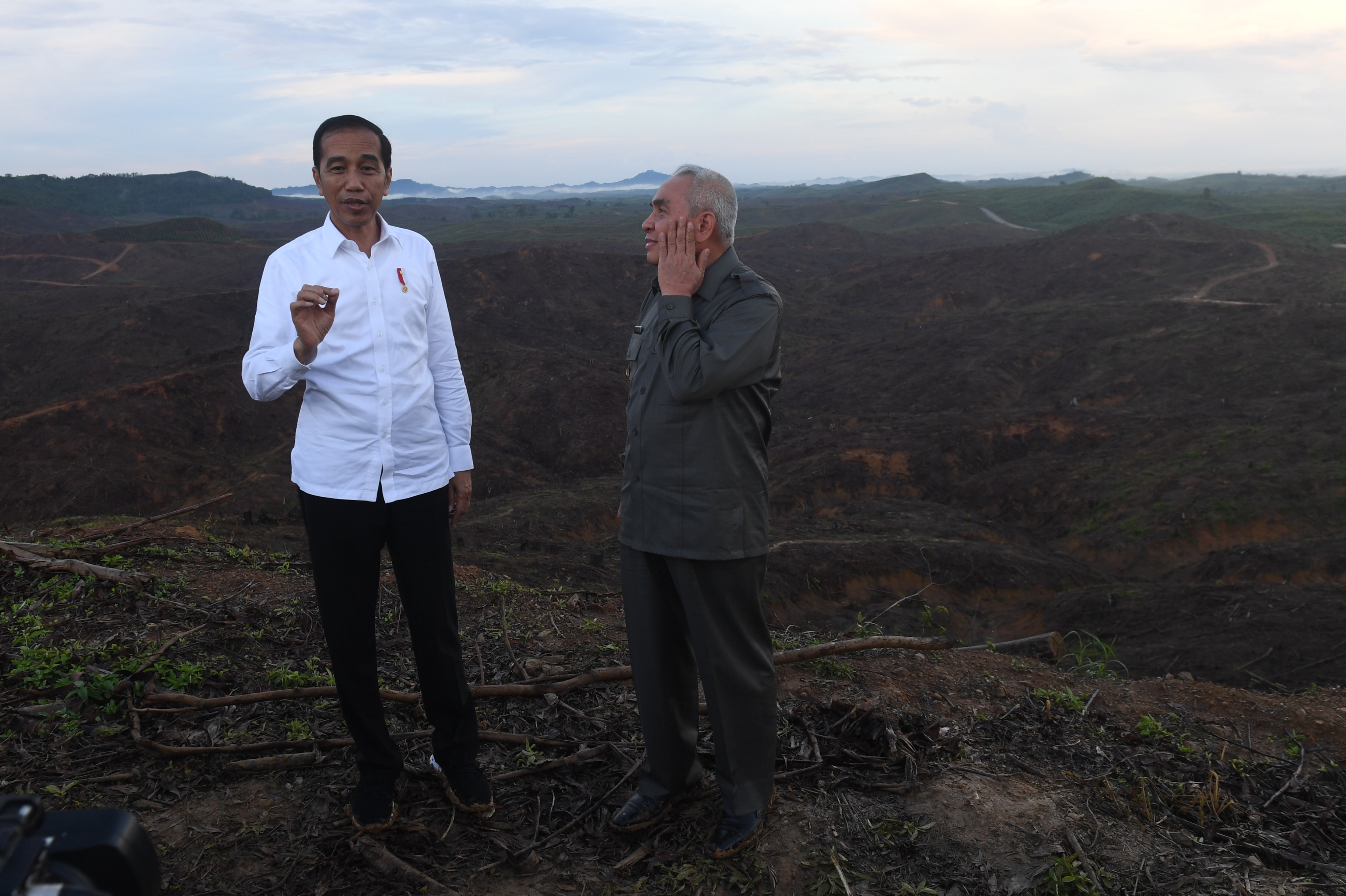 Presiden Joko Widodo (kiri) berbincang dengan Gubernur Kalimantan Timur Isran Noor (kanan) saat meninjau lokasi rencana ibu kota baru.