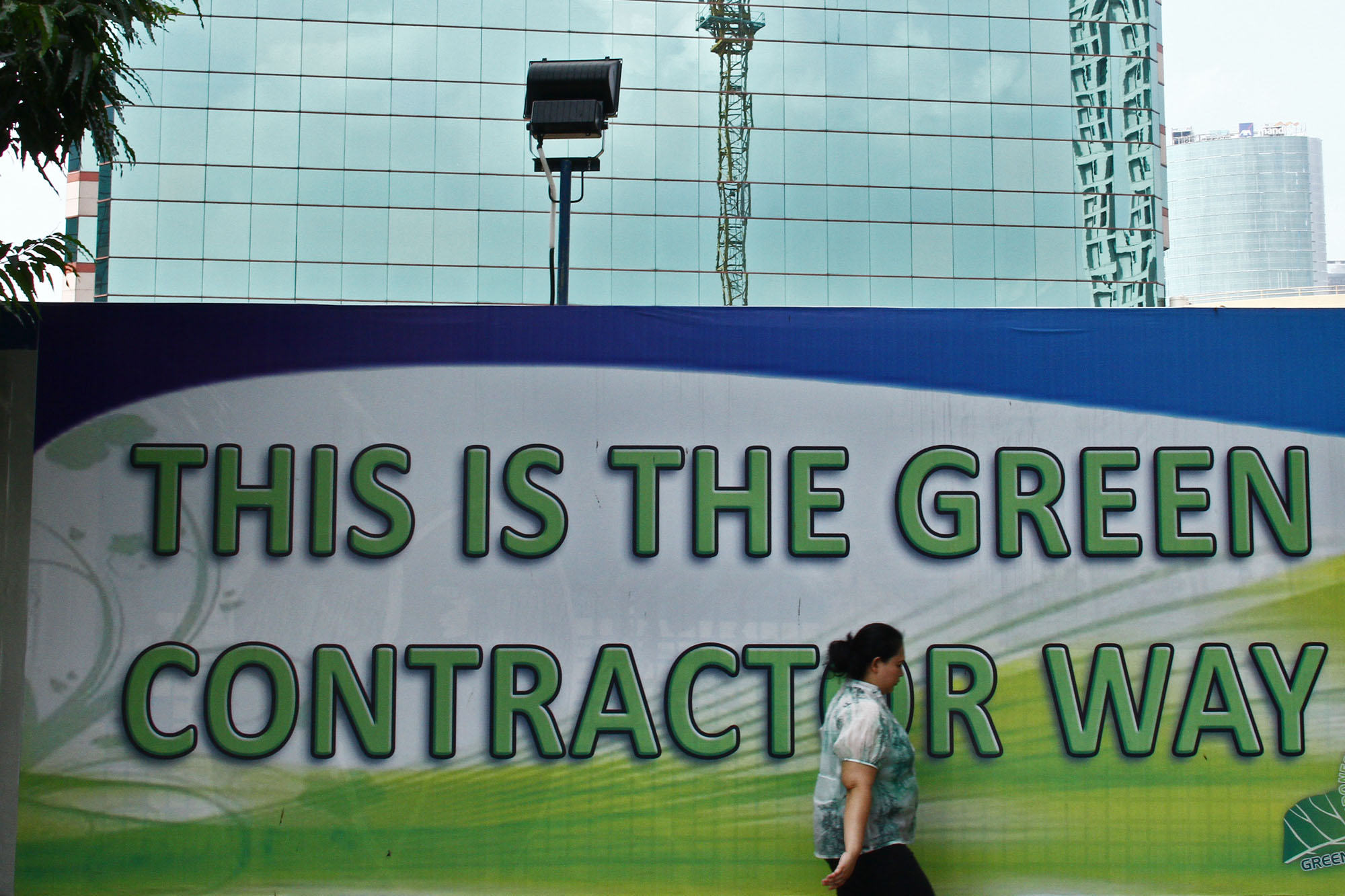 Pejalan kaki melintas di depan spanduk kampanye Green Building di Jakarta, beberapa waktu silam.