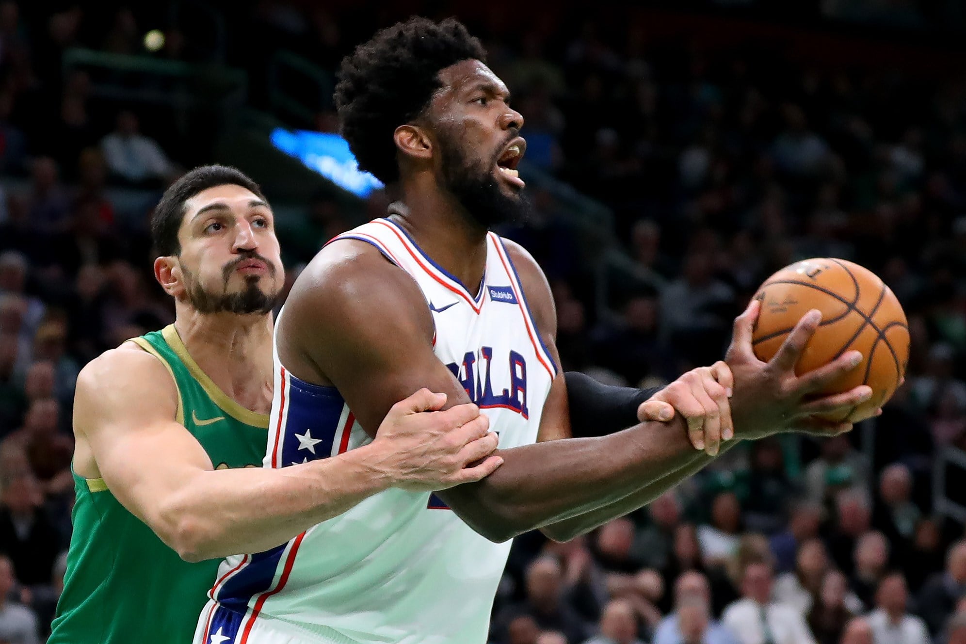 Pemain Boston Celtics, Enes Kanter (kiri), menghalangi gerak Joel Embiid dari Philadelphia 76ers pada laga di TD Garden, Boston, Massachuset