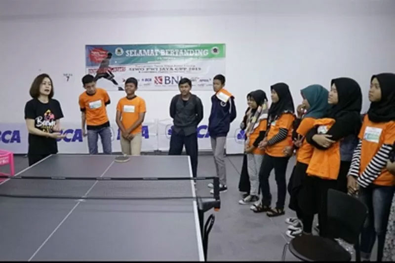 Mantan petenis meja nasional Evi Sumendap (paling kiri) memberi pelatihan tenis meja kepada pelajar SMP dalam rangkaian acara Piala SIWO PWI