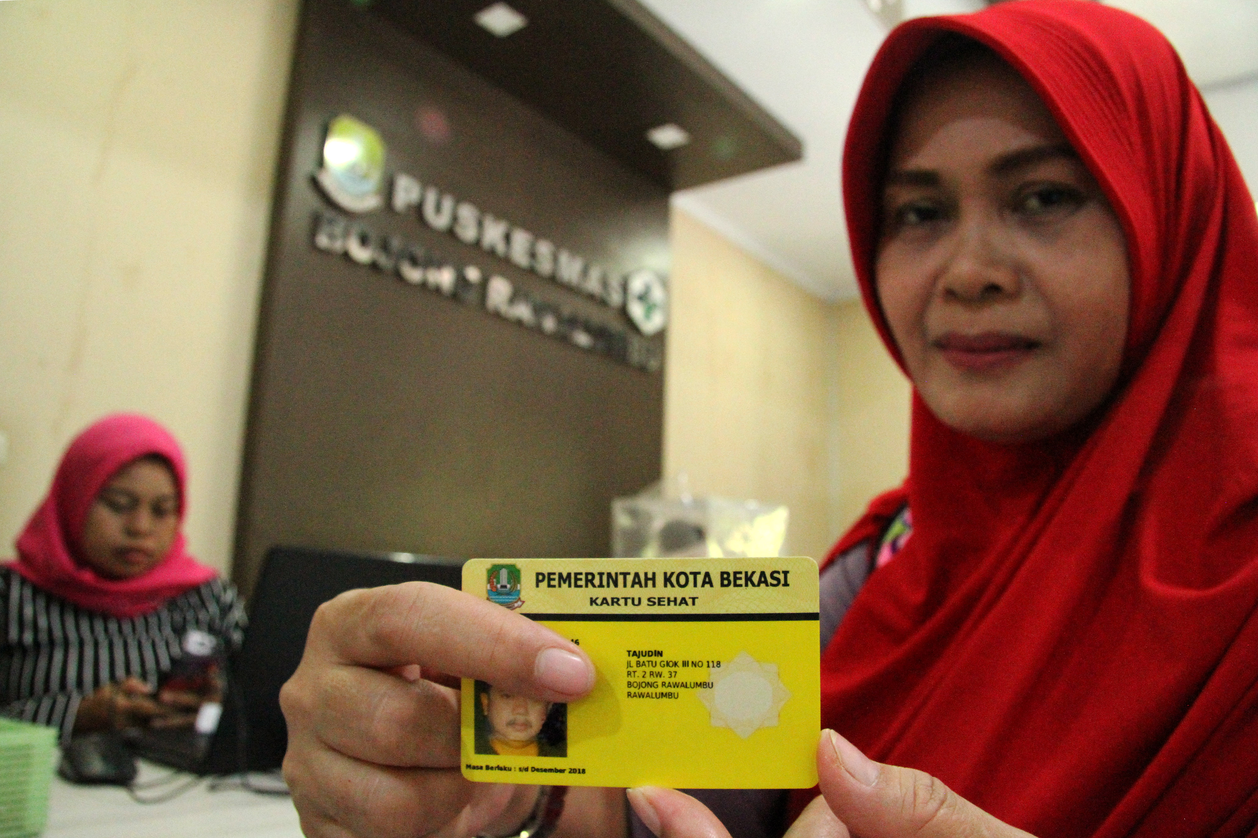 Warga memperlihatkan kartu sehat berbasis nomor induk KTP Kota Bekasi saat melakukan proses berobat sakit, di salah satu Puskesmas
