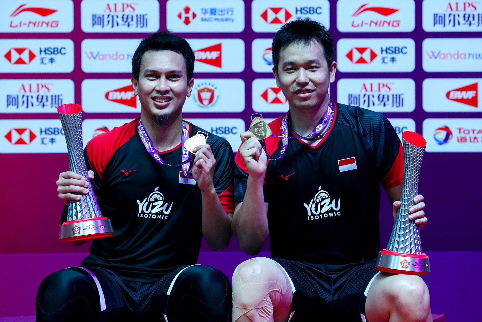 Ganda putra Indonesia Hendra Setiawan (kanan) dan Mohammad Ahsan menunjukan medali dan piala  BWF World Tour Finals 2019.