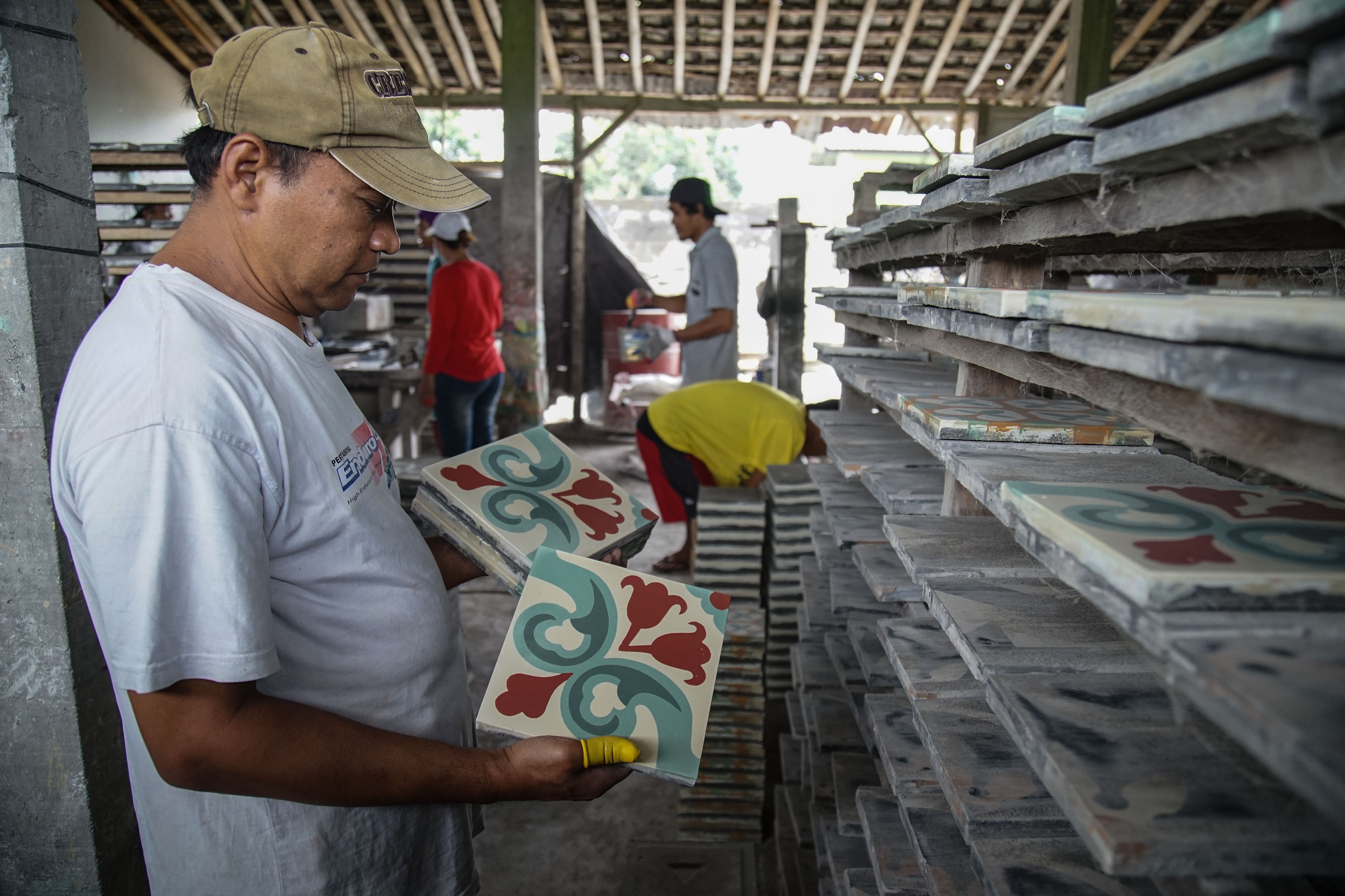 Pekerja menyelesaikan pembuatan tegel motif atau keramik lantai bermotif di Keniten, Tamanmartani, Kalasan, Sleman, DI Yogyakarta