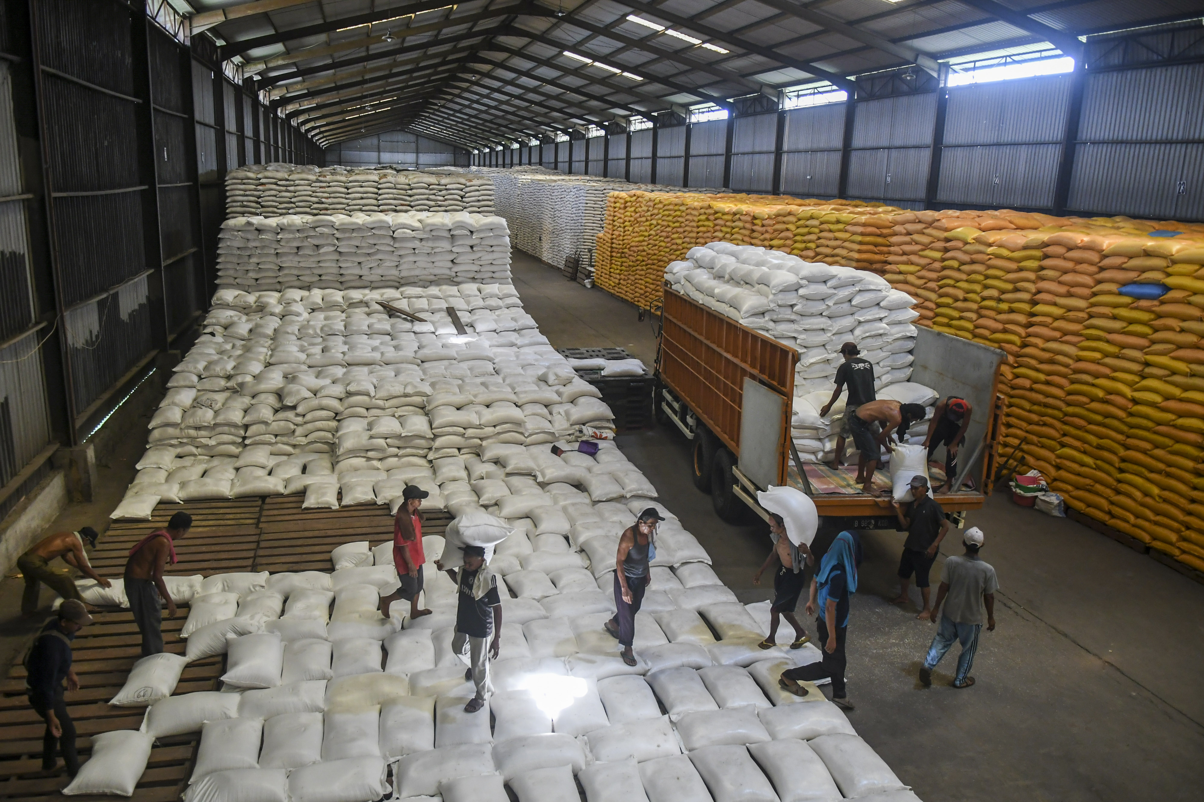 Pekerja mengangkut karung berisi beras di Gudang Perum Bulog Divre DKI Jakarta dan Banten, Kelapa Gading, Jakarta, Kamis (5/12/2019).