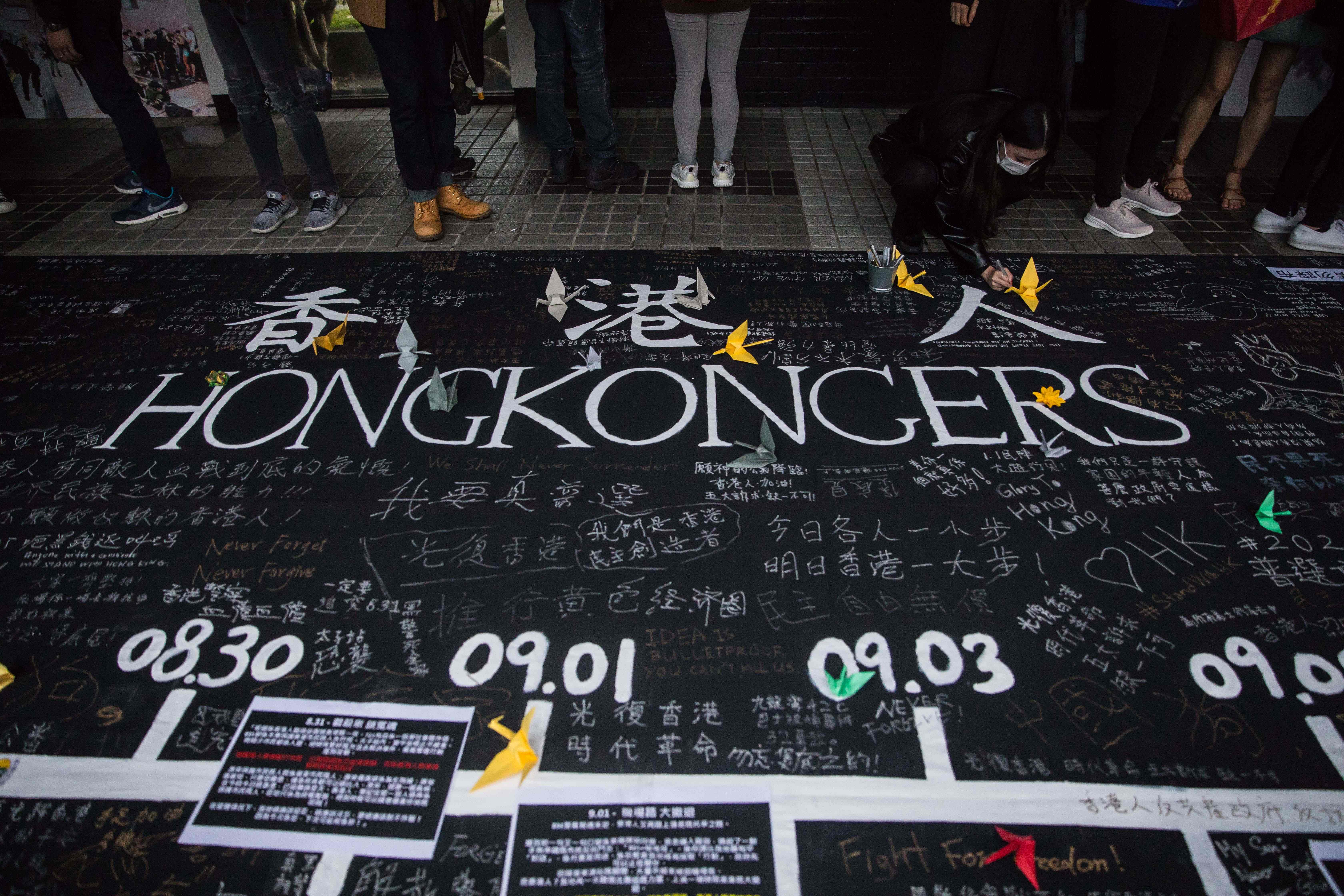 Demonstran pro-demokrasi menyampaikan pesan pada spanduk di Edinburgh Place, distrik tengah Hong Kong, Minggu (29/12).