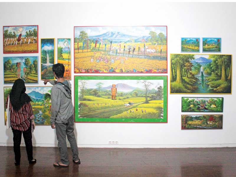 egunjung sedang mengamati lukisan yang dipamerkan di Jogja National Museum dalam pameran karya seni Biennale Jogja Equator #5.
