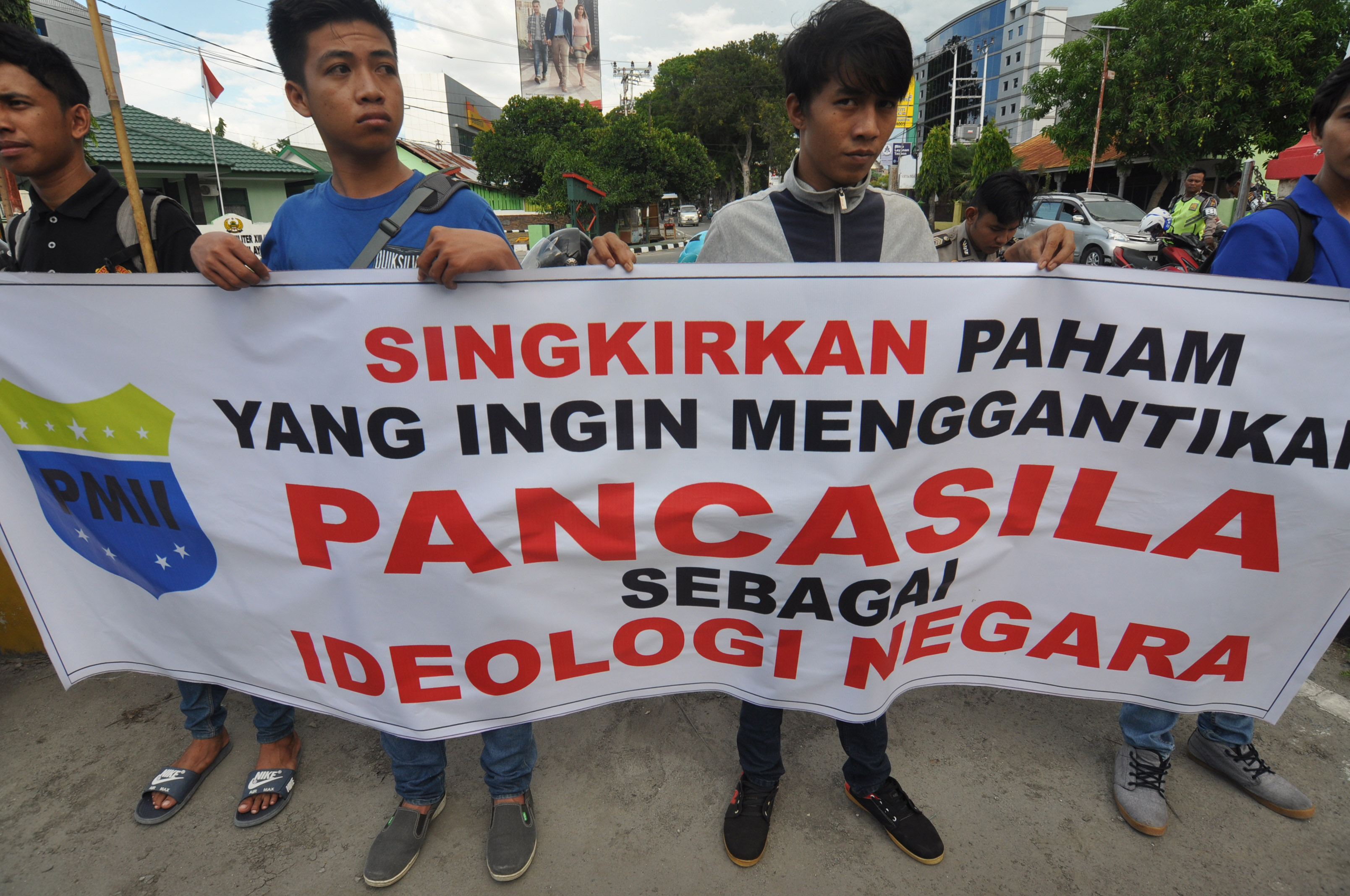 Sejumlah pengunjuk rasa dari PMII Sulawesi Tengah membawa poster saat melakukan aksi unjuk rasa di Bundaran Hasanudin Palu, Sulawesi Tengah