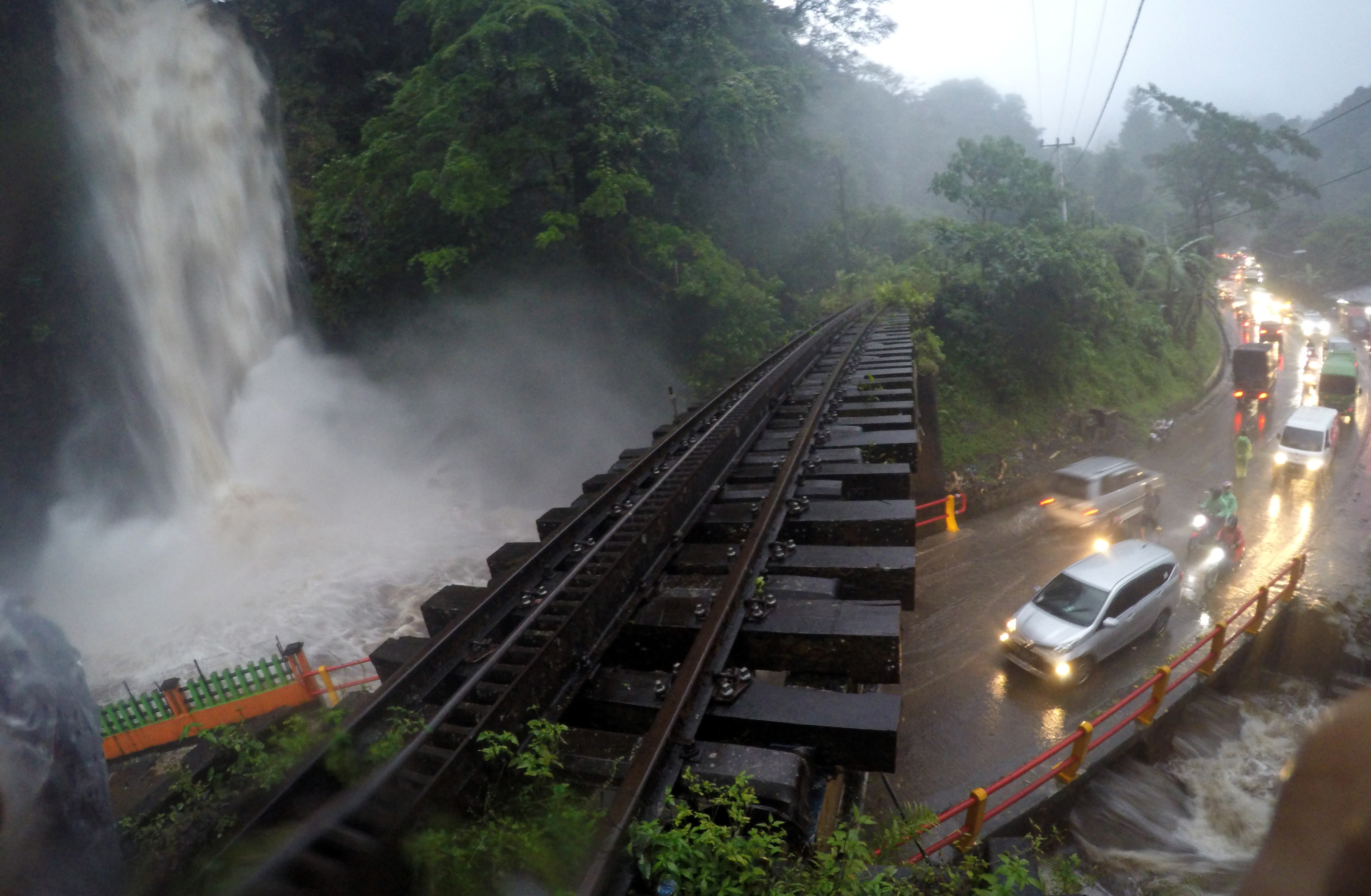 Sejumlah kendaraan melintas bergantian di depan Air Terjun Lembah Anai yang meluap, di Kab.Tanah Datar, Sumatera Barat, Minggu (22/12)