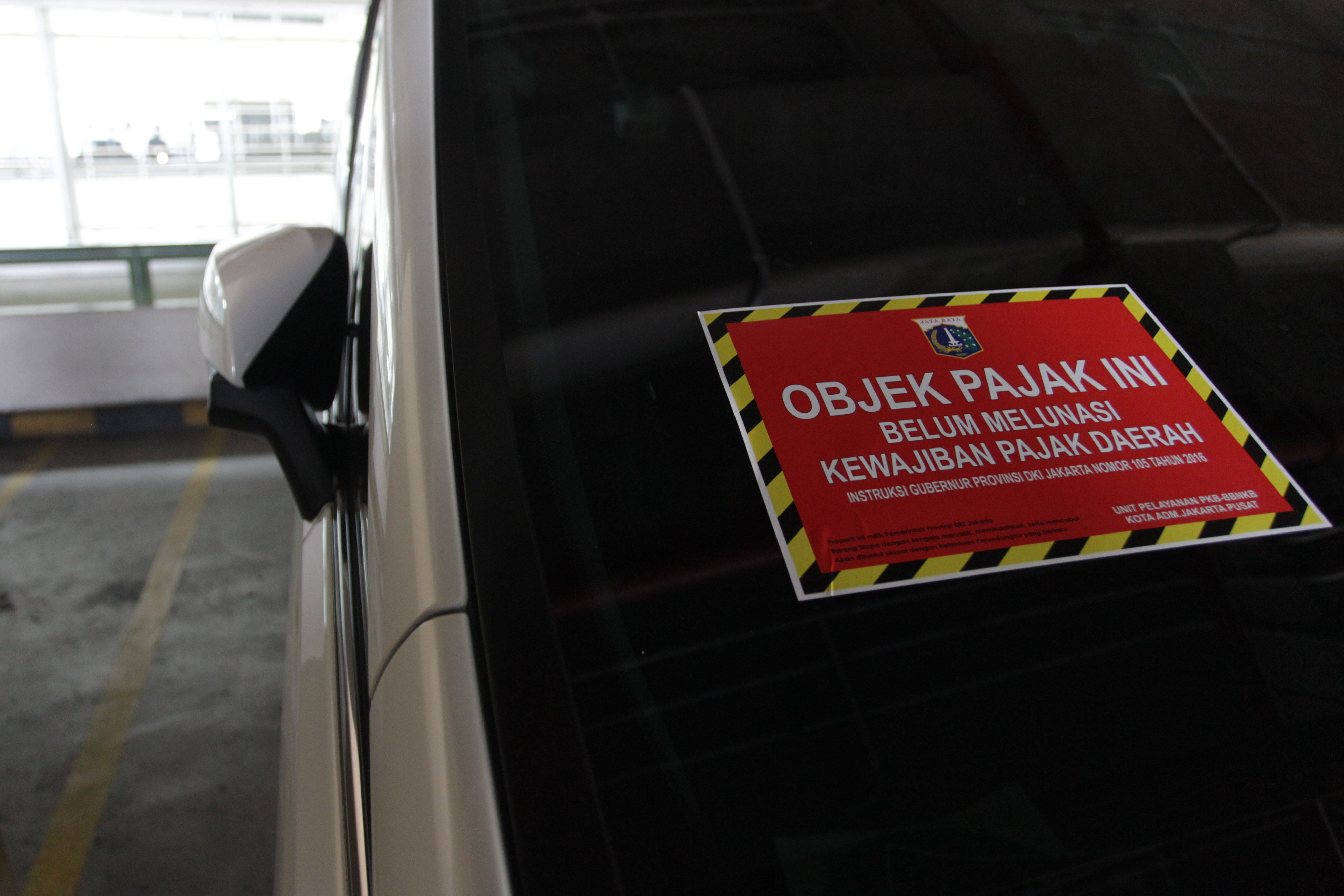 Sebuah mobil ditempeli stiker karena belum membayar pajak.