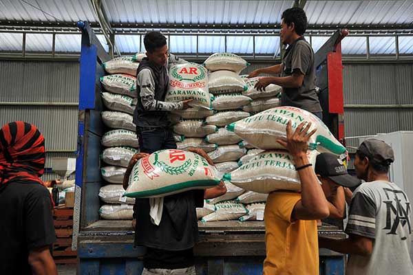 Ilustrasi -- Pekerja menurunkan karung berisi beras kualitas premium di Gudang Bulog Sub Divisi Regional Serang, Banten, Jumat (2/8/2019)