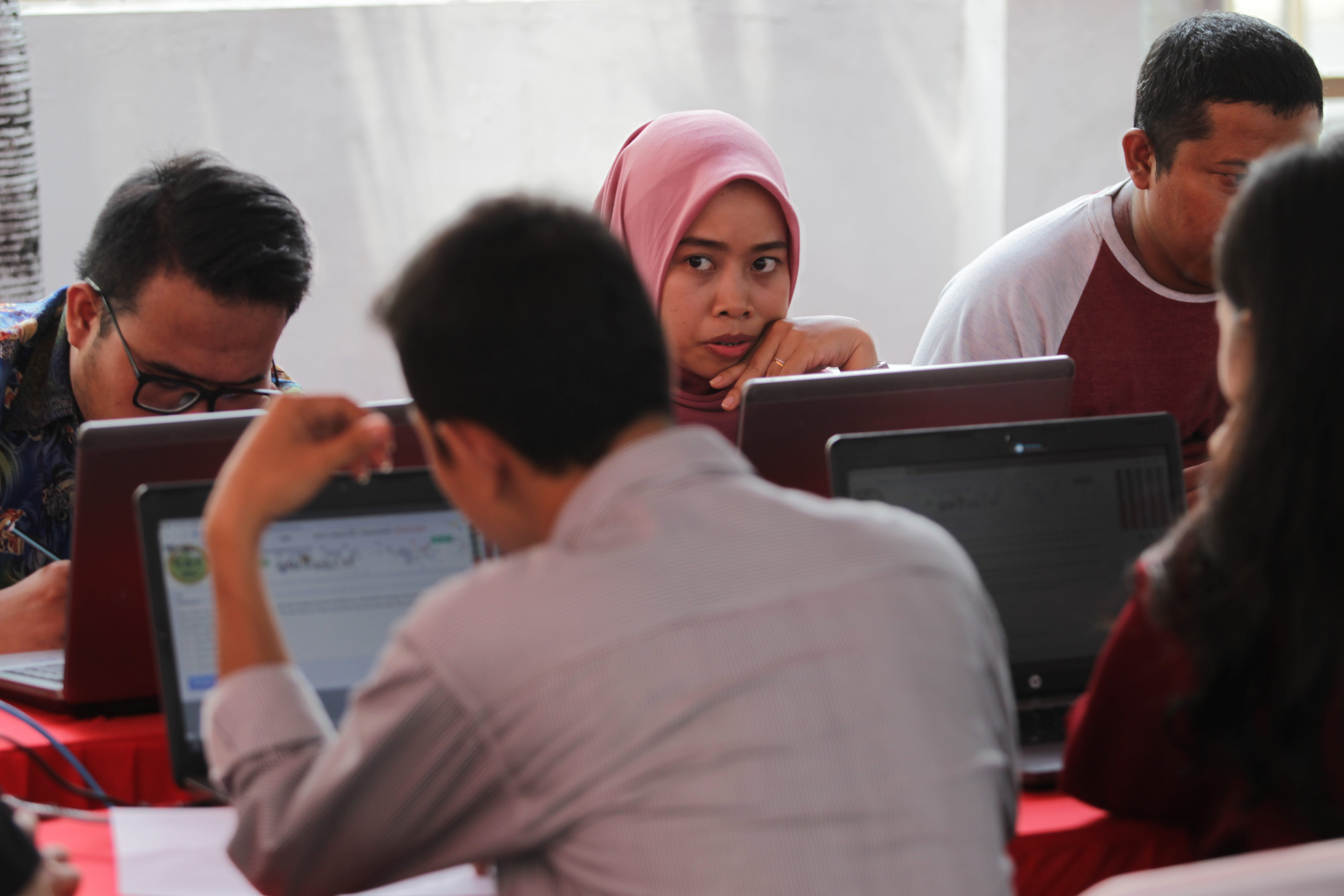 Peserta mengerjakan soal-soal saat mengikuti simulasi ujian penerimaan CPNS di halaman parkir pusat perbelanjaan Sarinah, Jakarta.